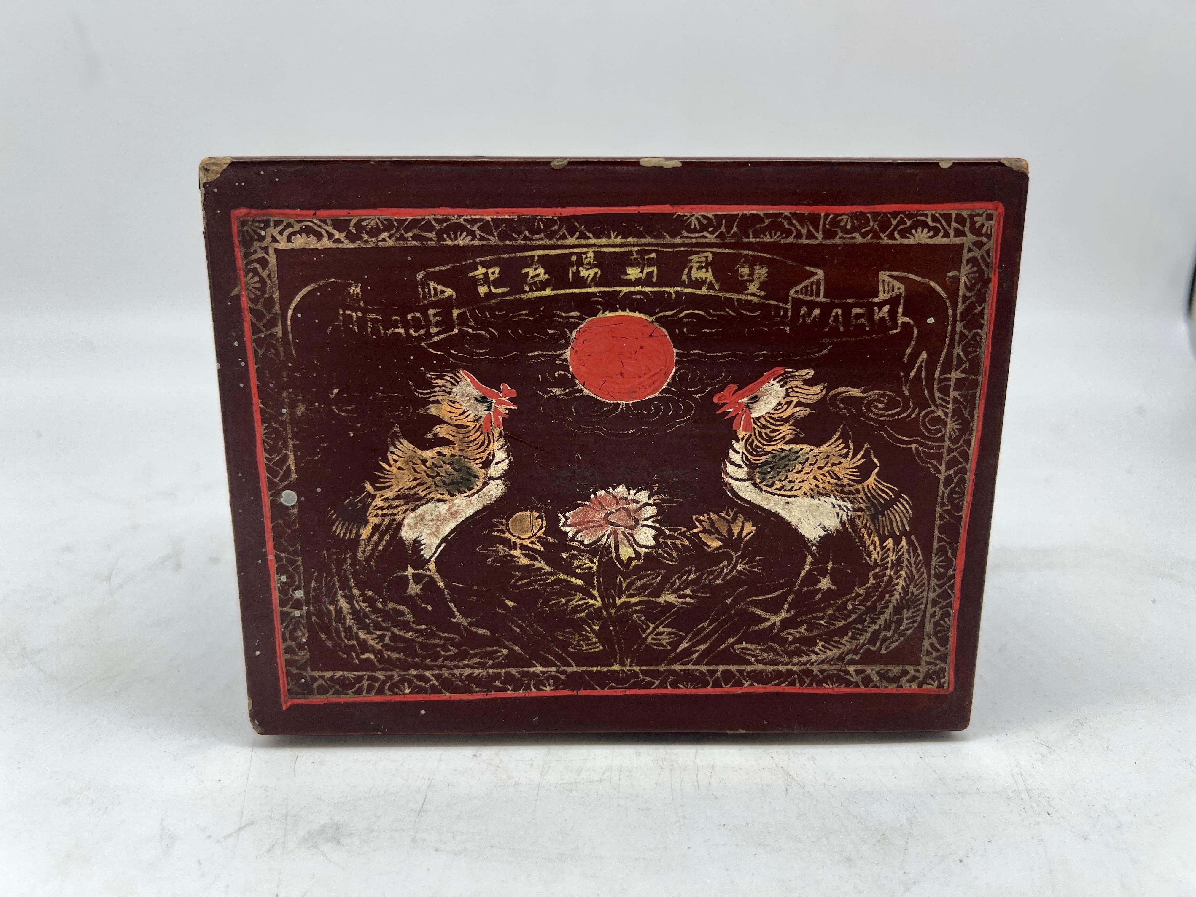 Chinois, début du 20e siècle. 

Une boîte ancienne en laque rouge avec des poulets décorés de dorures, de lettres chinoises et d'autres symboles. Marquage du fabricant sur la boîte.
