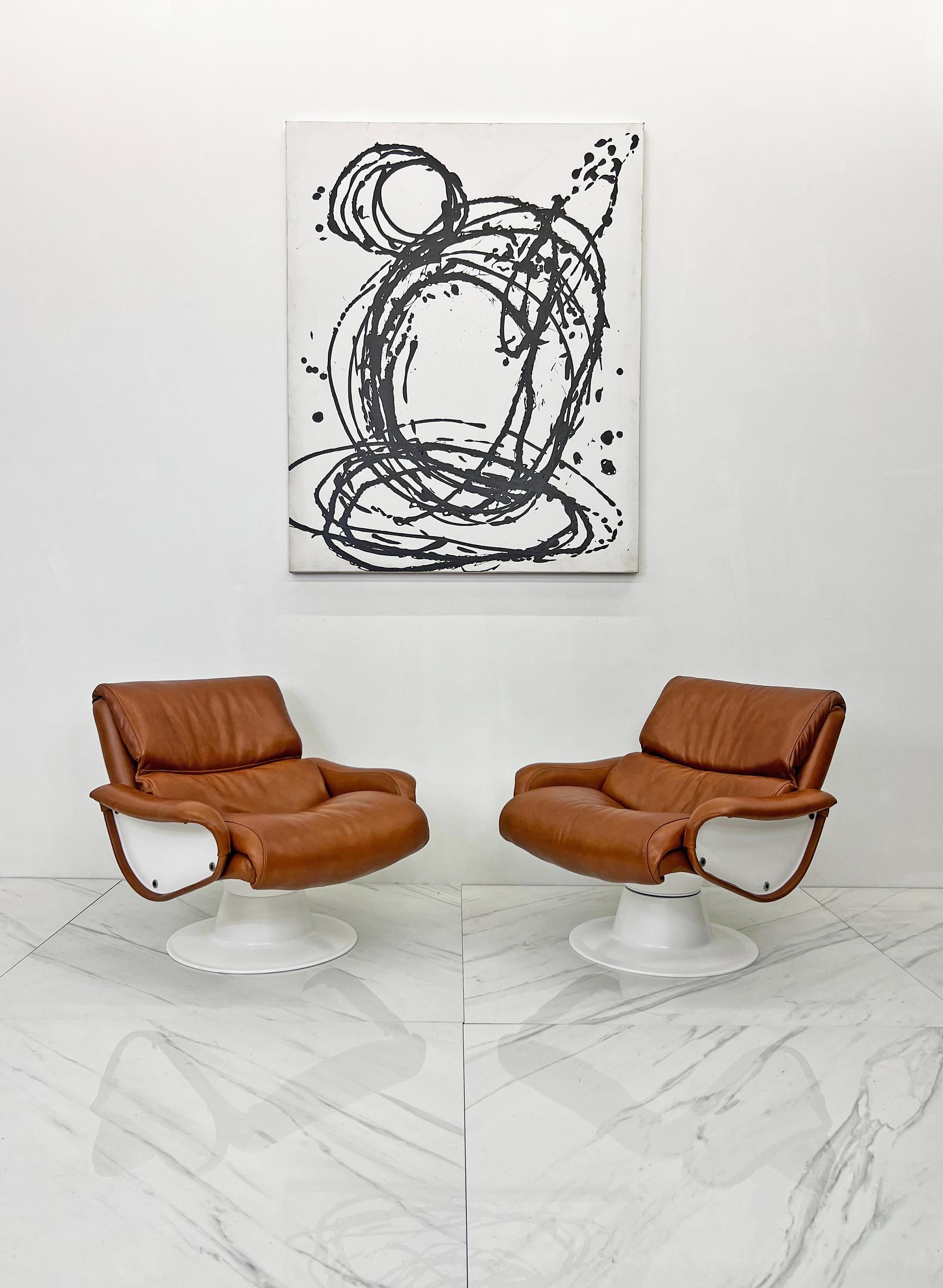 These chairs are iconic Mid-Century Modern design at its finest! These lounge chairs were designed by Yjro Kukkapuro for Haimi, Finland in 1966. They feature a fiberglass body, and sumptuous cognac leather. Priced per pair, we currently have 2 pairs