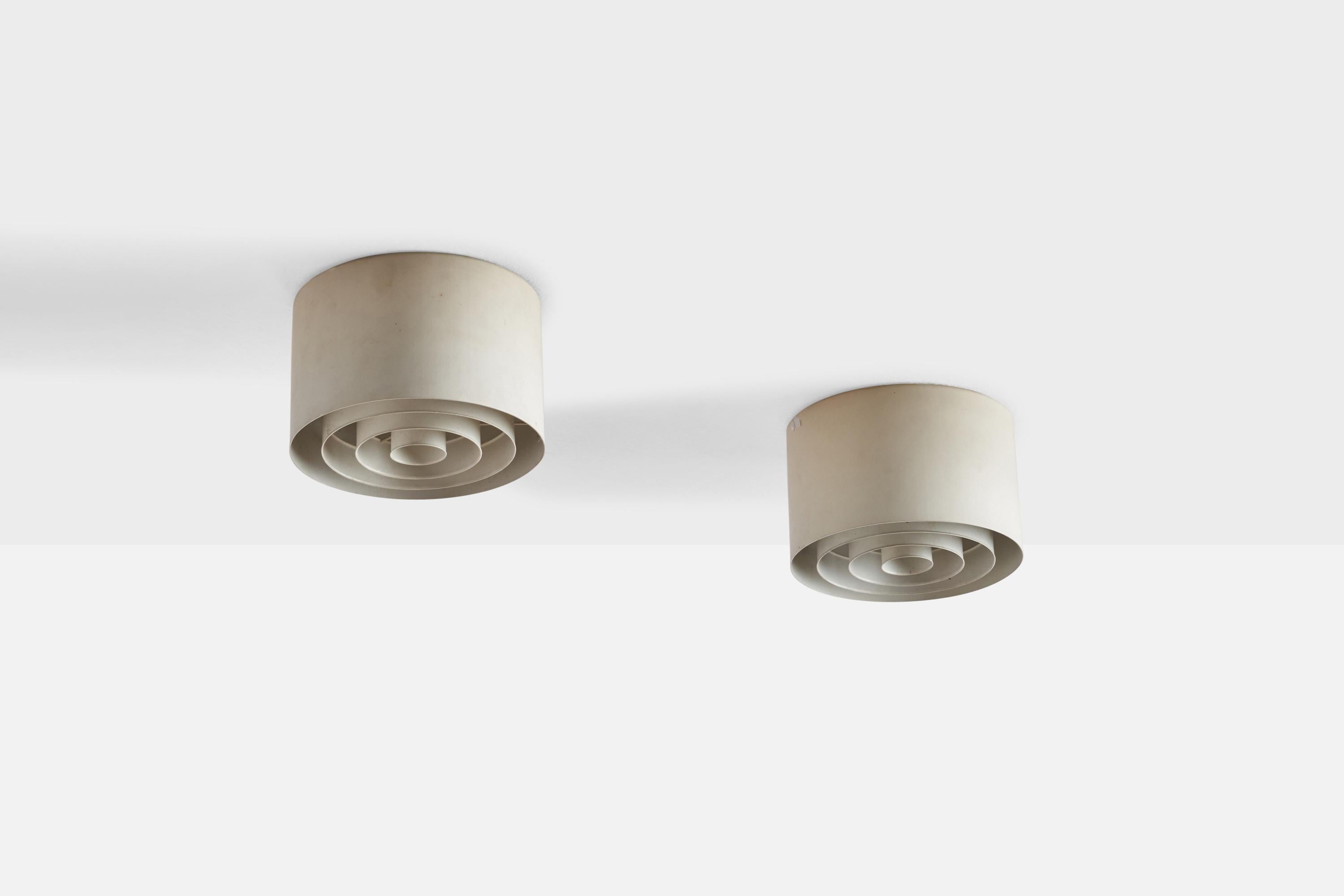 A pair of white-lacquered metal flush mounts designed by Yki Nummi and produced by Ornö, Finland, 1960s.

Dimensions of canopy (inches): N/A
Socket takes standard E-26 bulbs. 2 sockets.There is no maximum wattage stated on the fixture. All lighting