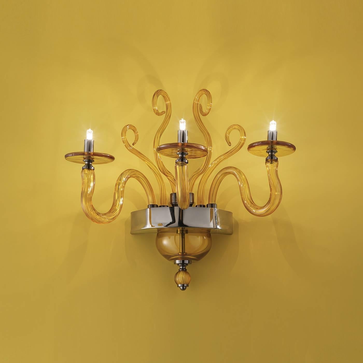 Inspired by the traditional shape of 18th century chandeliers reinterpreted in a contemporary way, the Yncanto wall light creates a timeless accent that will complement any decor. Handcrafted of glass in a delicate amber color, three S-shaped glass