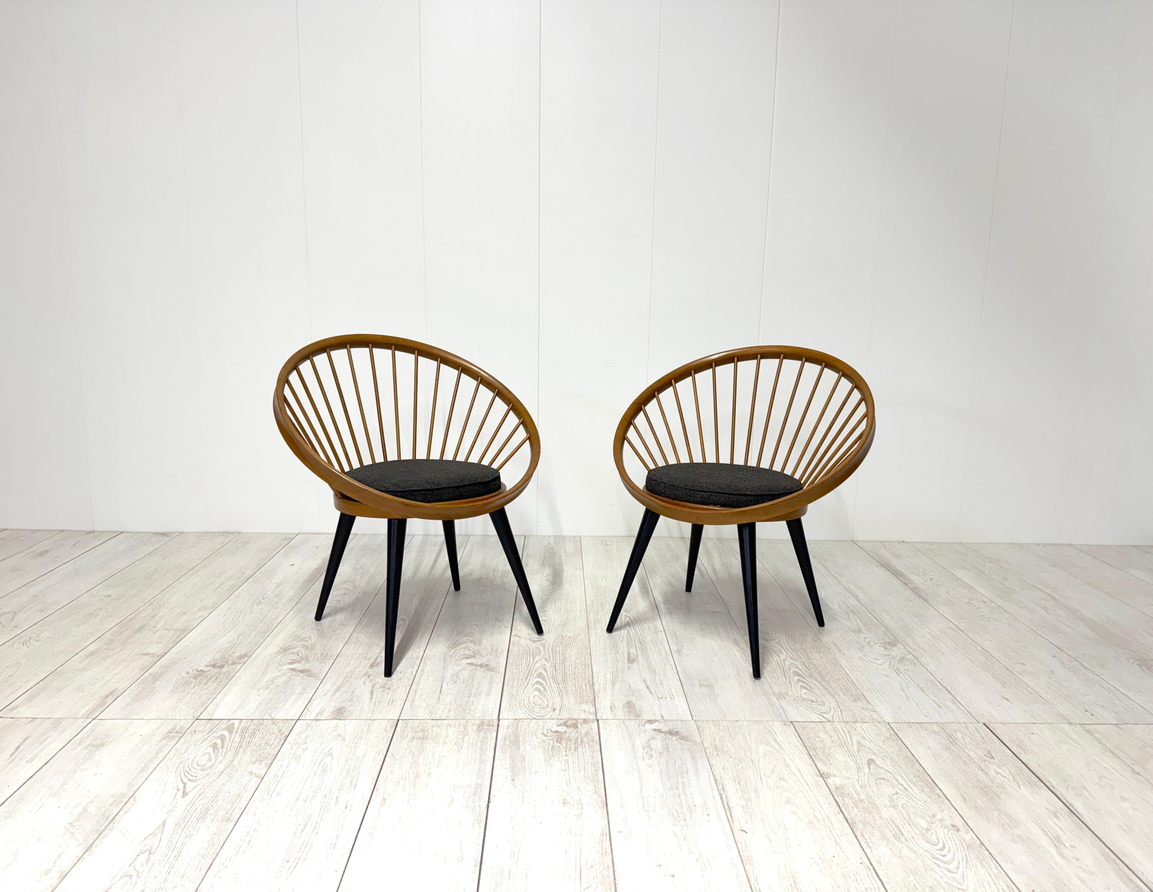 Pair of armchairs i wood and fabric upholstered seat.
The Circle Chair gets its name from its distinctive circular backrest held together by round rods.

Designed in 1958 by Swedish designer Yngve Ekström for Italian manufacturer Gessef, the Circle