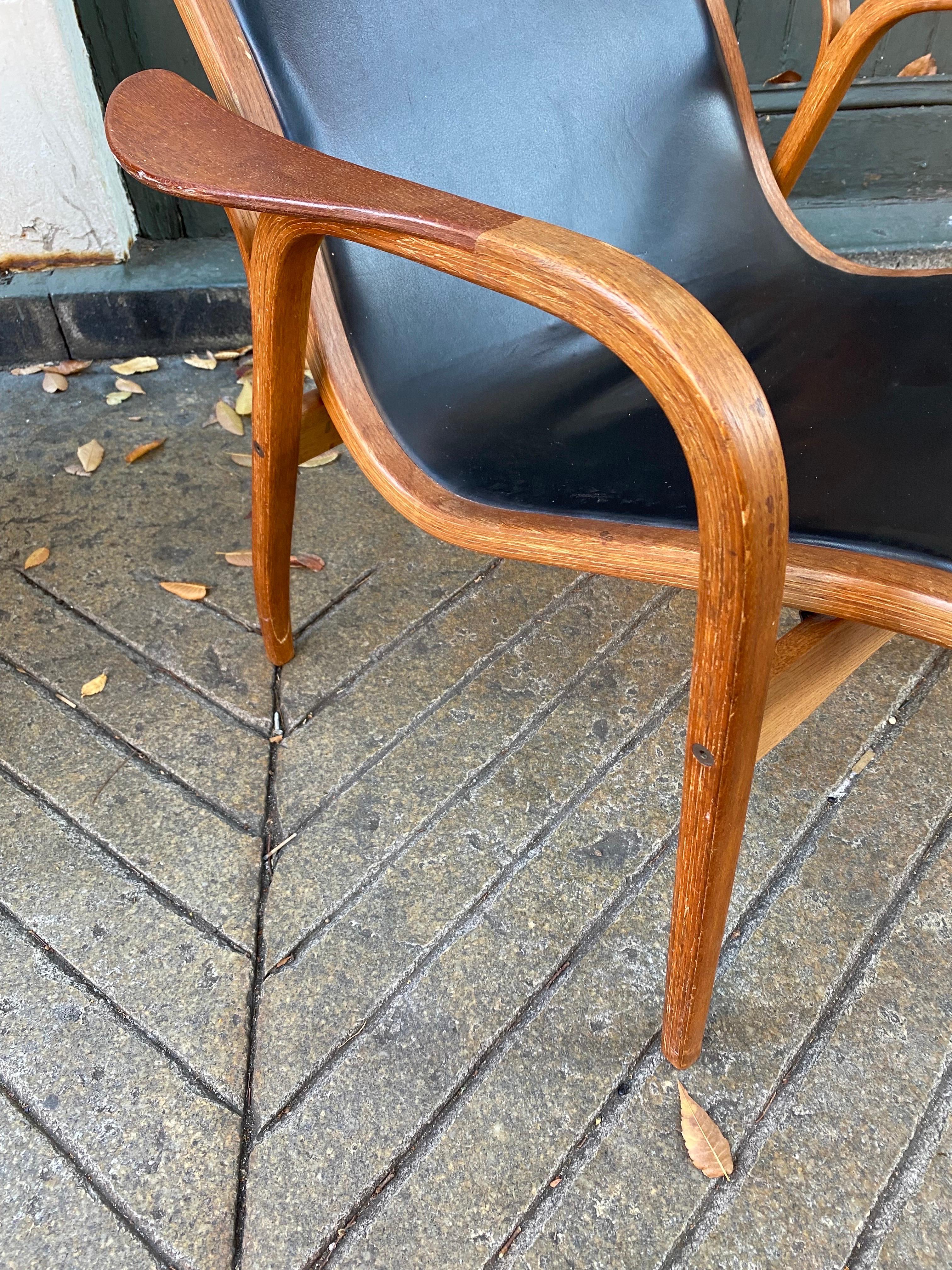 Lamino High Back Lounge Chair with a black vinyl Seat.  Molded Oak Frame with Teak Armpads.  Very comfortable light weight design!  Original Condition.  Several models of this chair available.