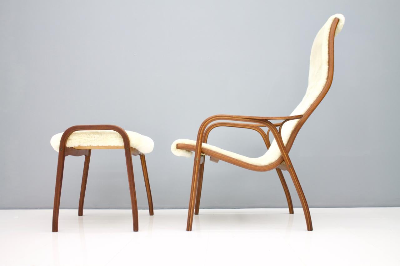 Very nice Lamino armchair with stool by Yngve Ekström for Swedese, 1956. This Armchair comes from the early 1960s.
Curved plywood, teak, upholstery with new cream colored Sheepskin.
Armchair: H 100 cm, W 70 cm, D 85 cm, SH 40 cm.
Stool: H 48 cm,