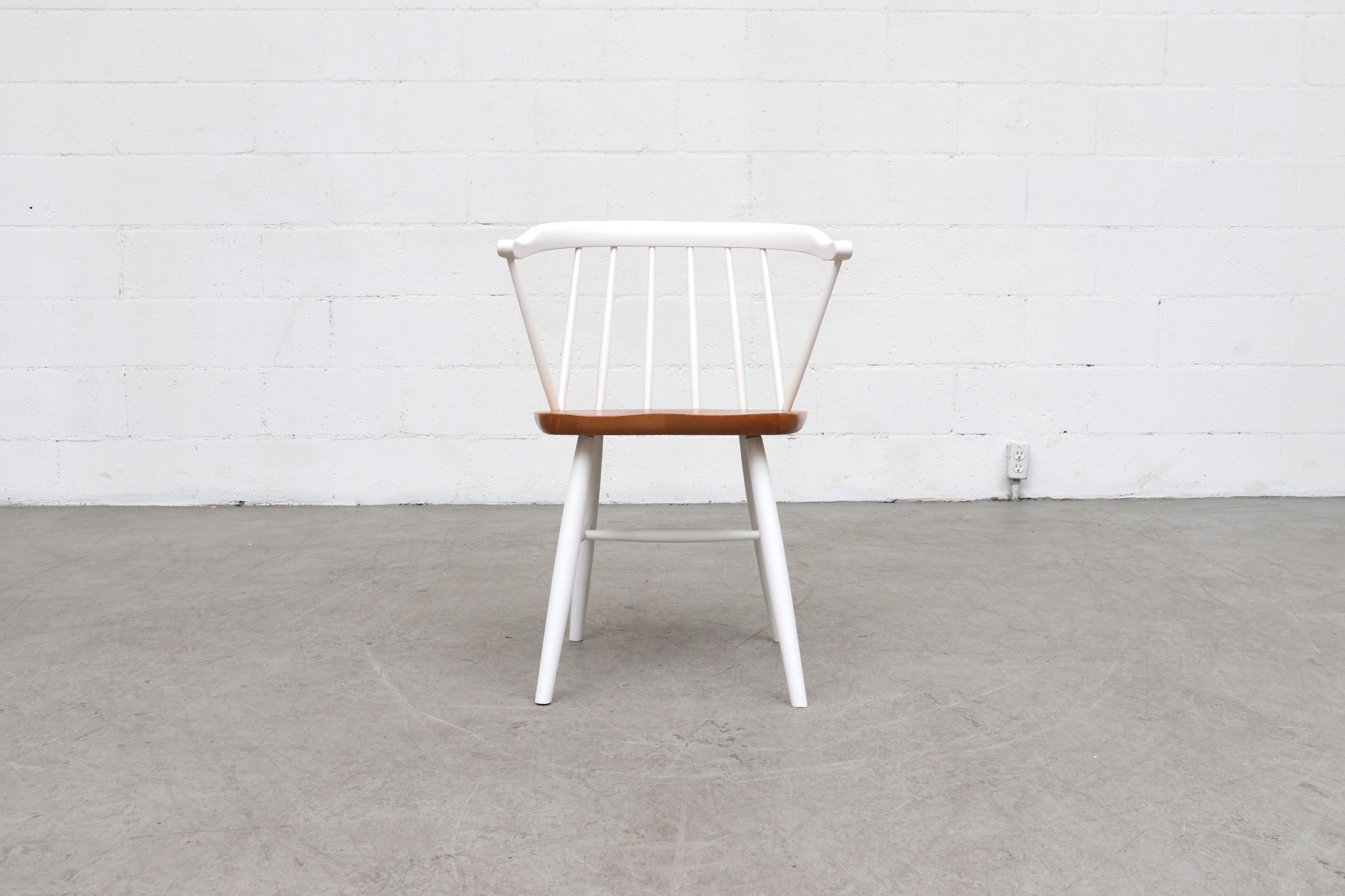 Cute white spindle back chair. White painted back and legs with natural wood seat. Lightly refinished. In otherwise original condition with some minor visible signs of wear, consistent with age and use.