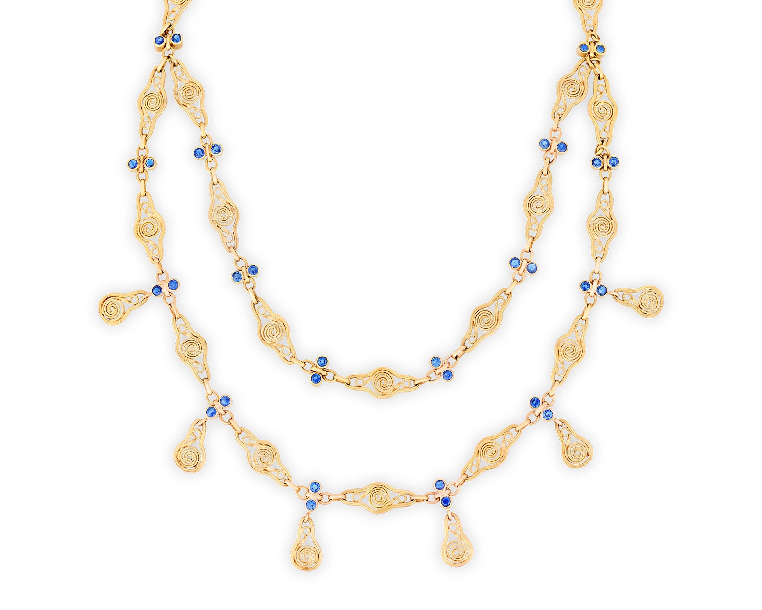 This Yogo sapphire and gold necklace, a masterful creation by Louis Comfort Tiffany, is a quintessential representation of the Art Nouveau style. It features a swirling festoon design, a popular motif of the era, emphasizing grace and fluidity. The