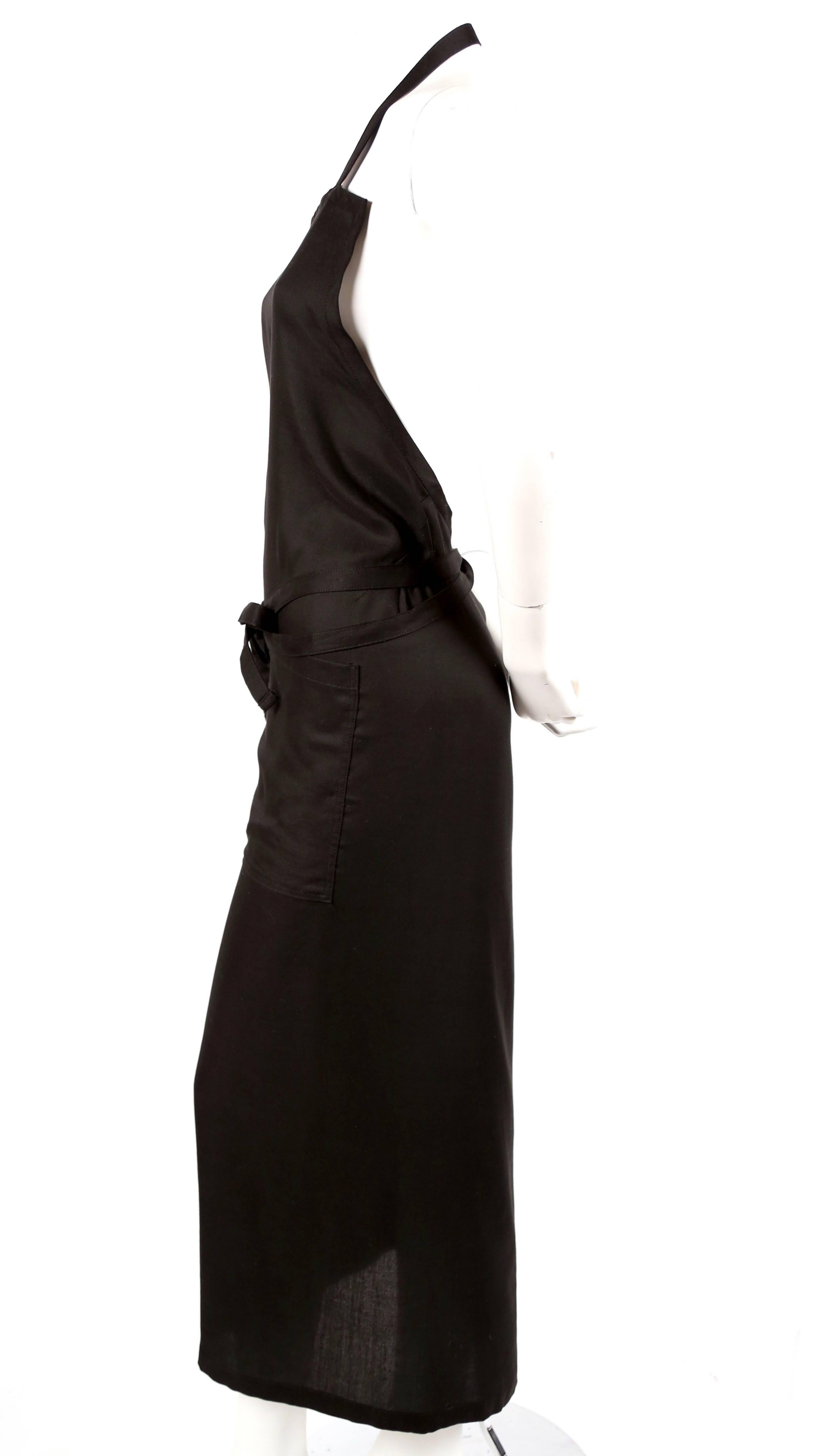 Jet-black, wrap dress with open back designed by Yohji Yamamoto. Japanese size 2 which best fits a size XS or S. No measurements are provided because dress is adjustable. It does however run small. Dress features wrap closure,  patch pockets, open