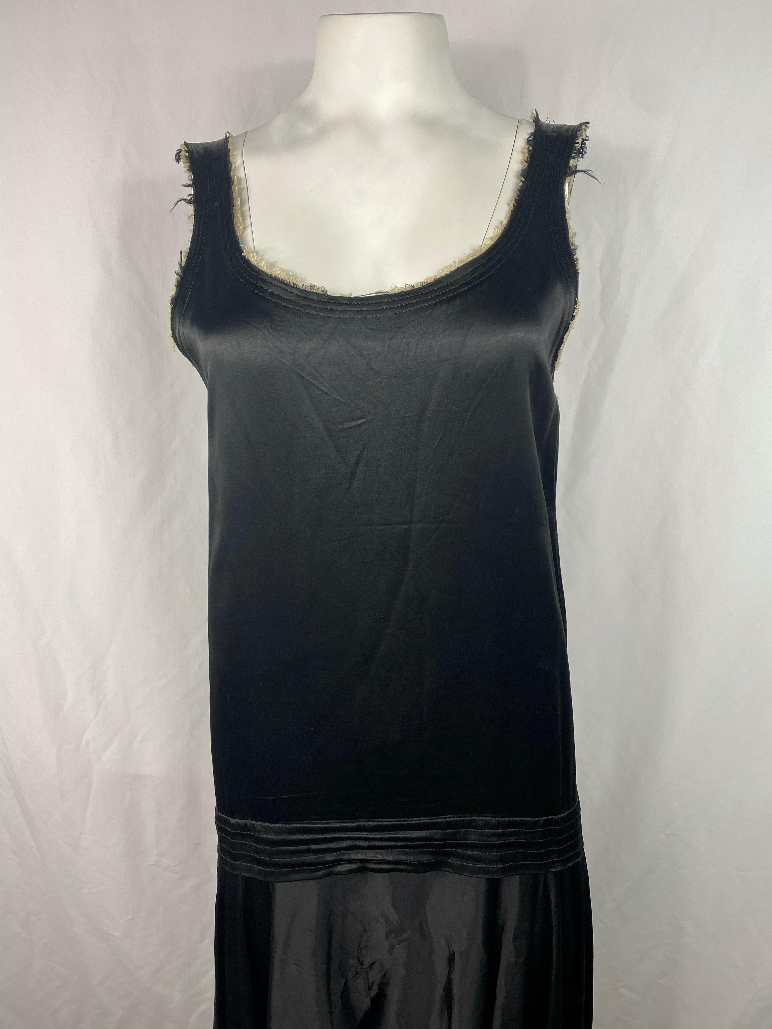 Detalles del producto:

El vestido es de color negro con ribetes beige, mangas, cuello redondo y falda asimétrica. Fabricado en Japón.