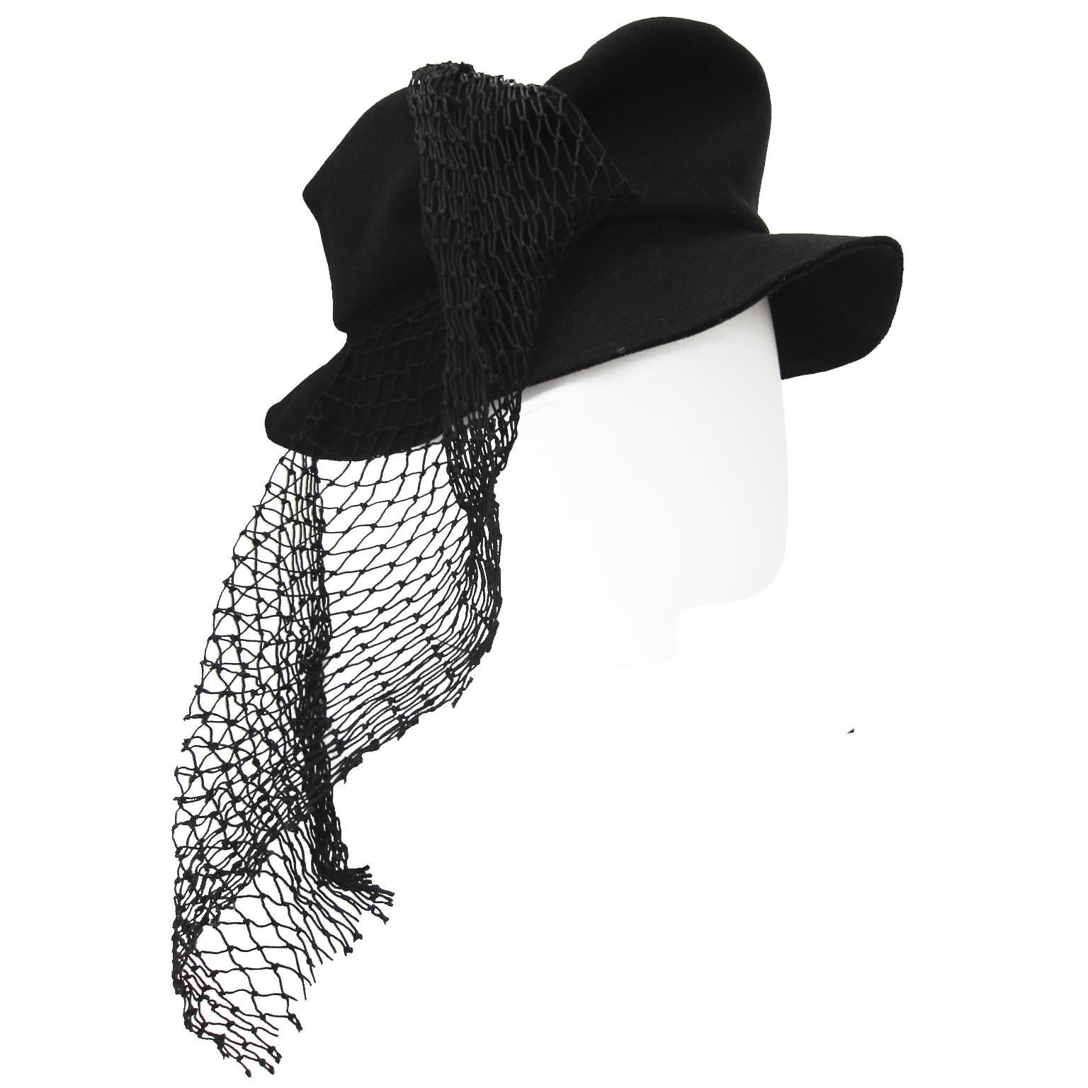 Rare Yohji Yamamoto black hat from circa SS 1999.
The hat is in black thin wool with a flat top, asymmetric draped mesh net material. Truly amazing piece. 
Inside hat measures : circa 59 cm