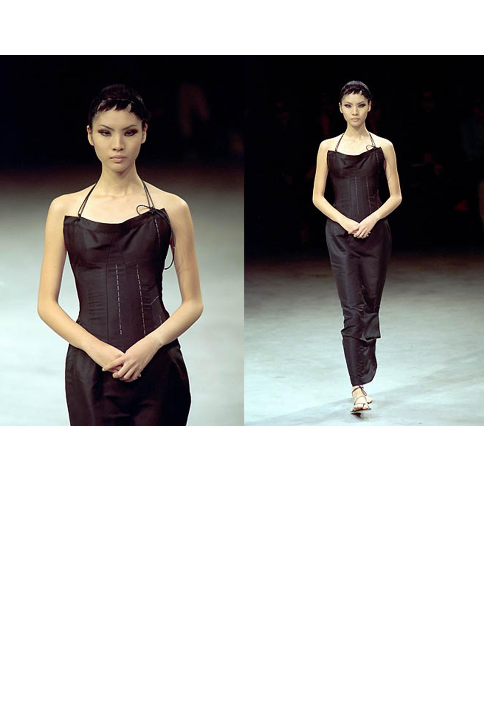 Resurrection Vintage a le plaisir de vous présenter une robe de soirée vintage en soie noire Yohji Yamamoto de la collection SS 2000, avec un dos nu et des bretelles en cuir à la taille, un dos ouvert, un corps ajusté, des points de bâti décoratifs