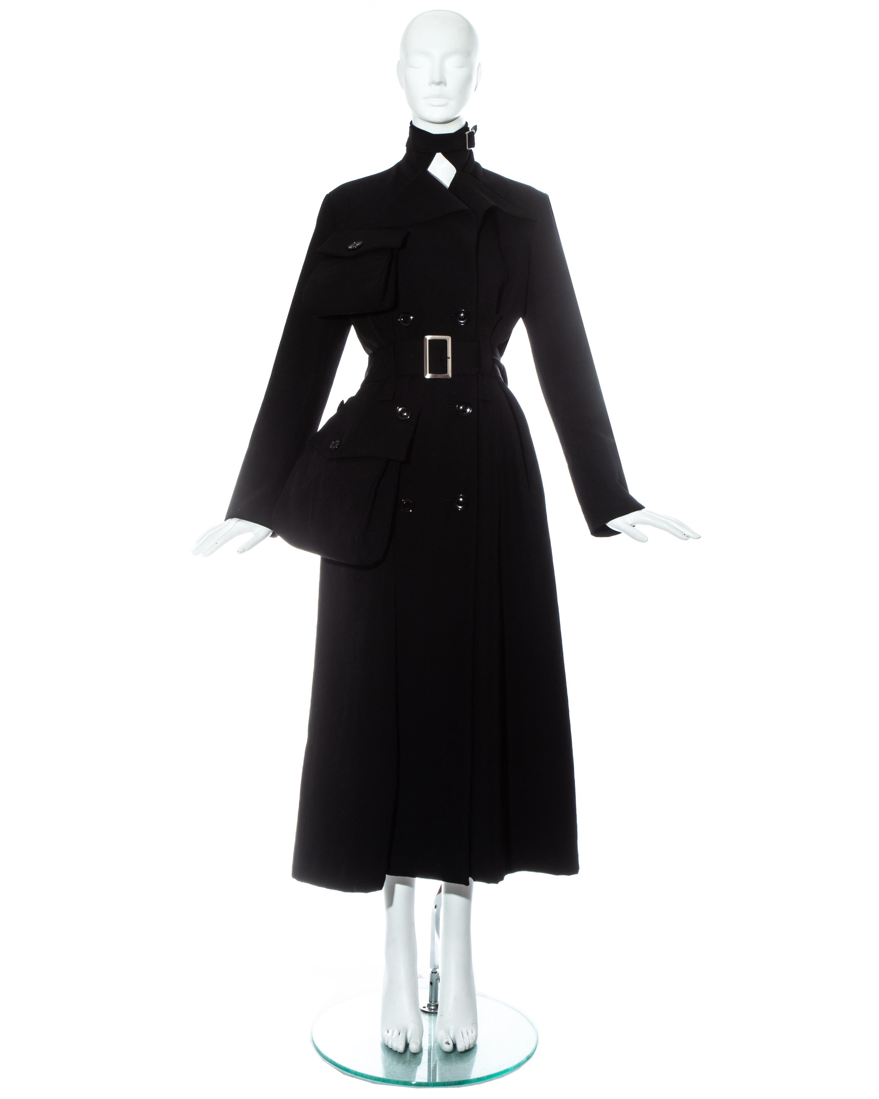 Yohji Yamamoto ; manteau maxi en gabardine de laine noire avec poches extérieures exagérées à rabat et fermetures à boucle de ceinture à la taille et au cou.  

 Automne-Hiver 2004   

- Le même manteau se trouve dans la collection permanente des