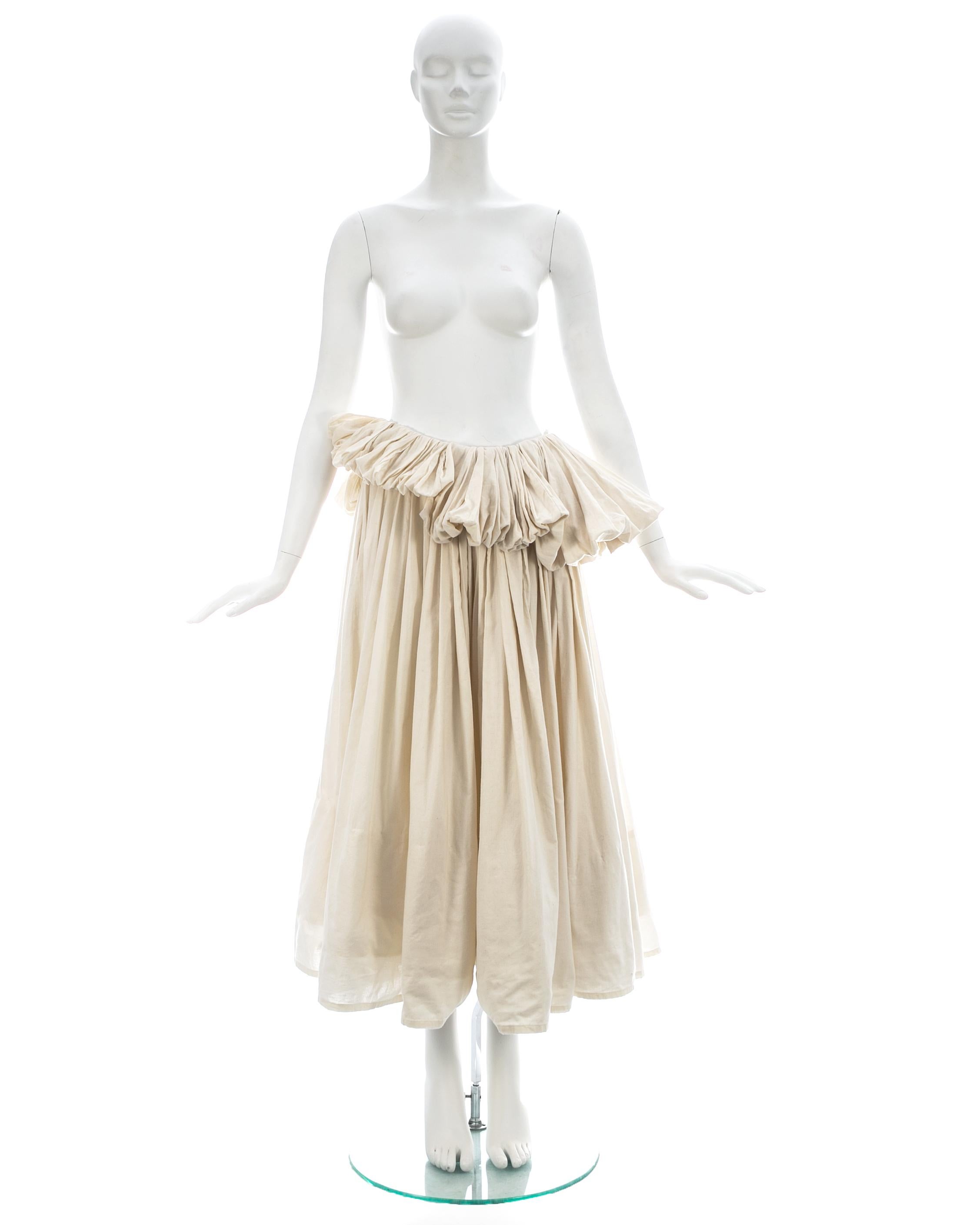 Yohji Yamamoto; Ivory cotton pleated peplum skirt with 2 side pockets, built-in padding at hem and elastic waistband 

Spring-Summer 2000