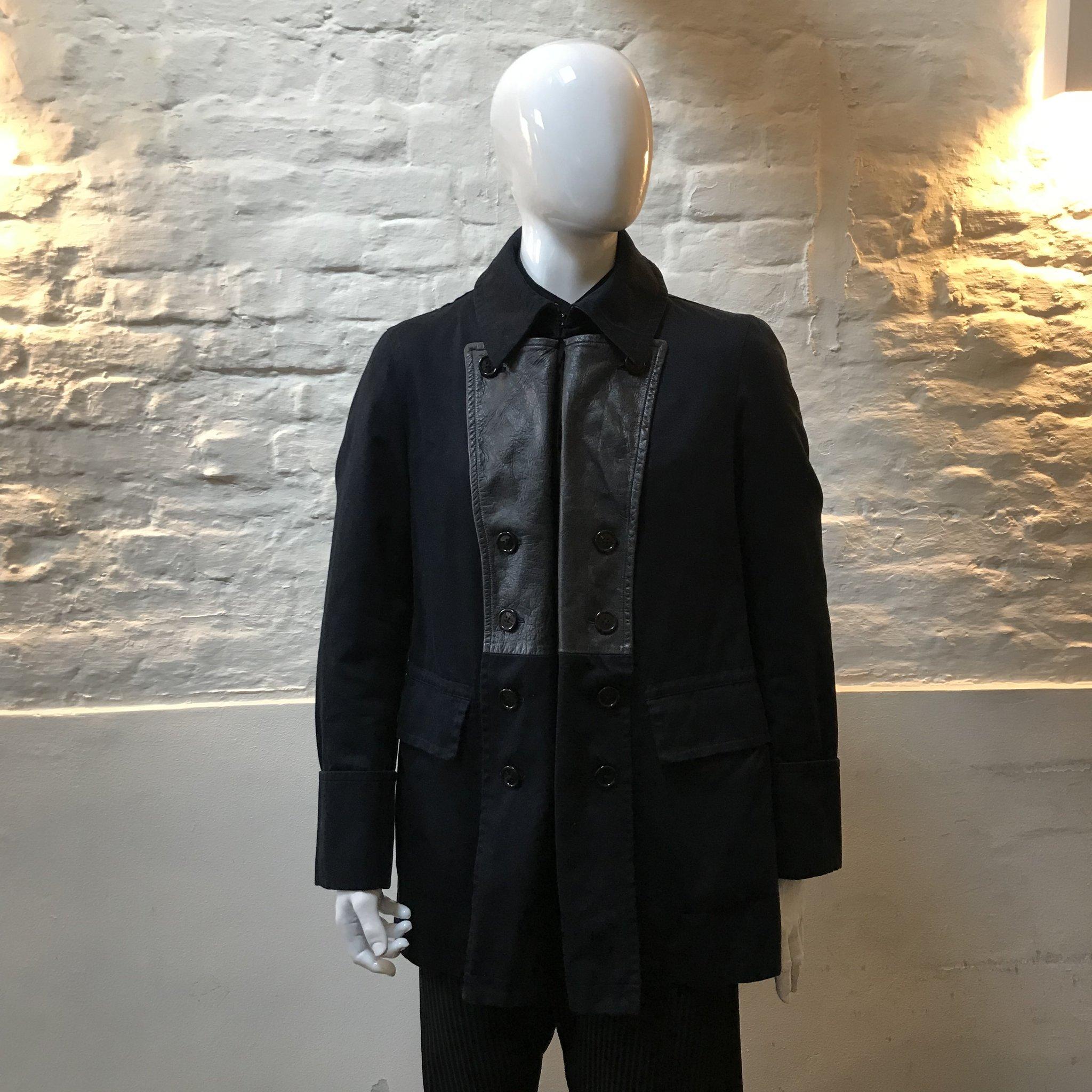 Yohji Yamamoto Leather Trim Pea Coat made in Japan from wool and leather. 

Yohji Yamamoto is known for the avant-garde spirit of his clothing. His signature oversized silhouettes in black often feature drapery in varying textures. Since the