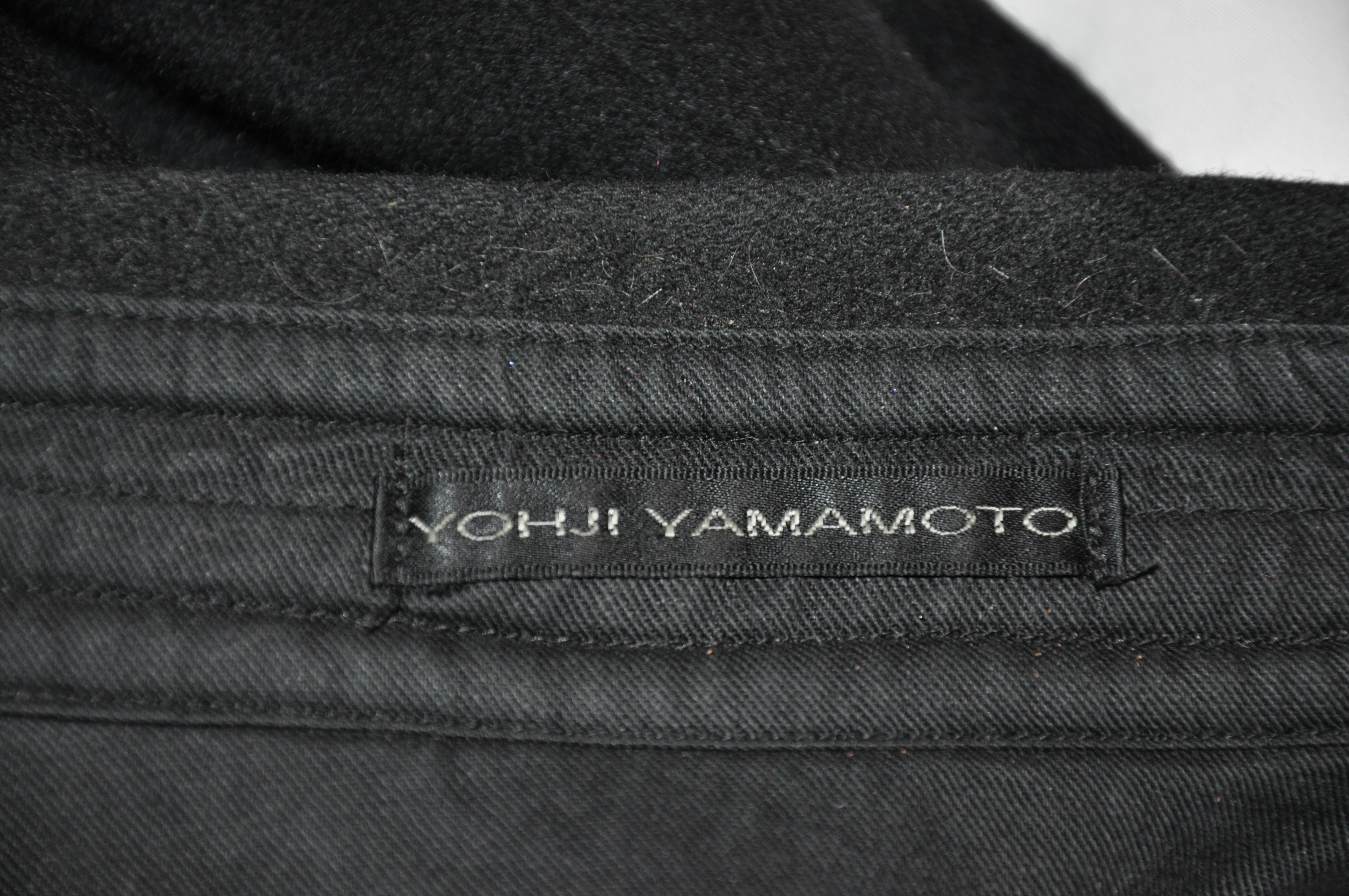    Yohji Yamamoto wonderful men's black 2-way zipper front is  accented with two patch breast buttoned patch pockets as well as the deconstructed scallop hemline. The armpits are detailed with eyelet for added comfort. Finished French seams are