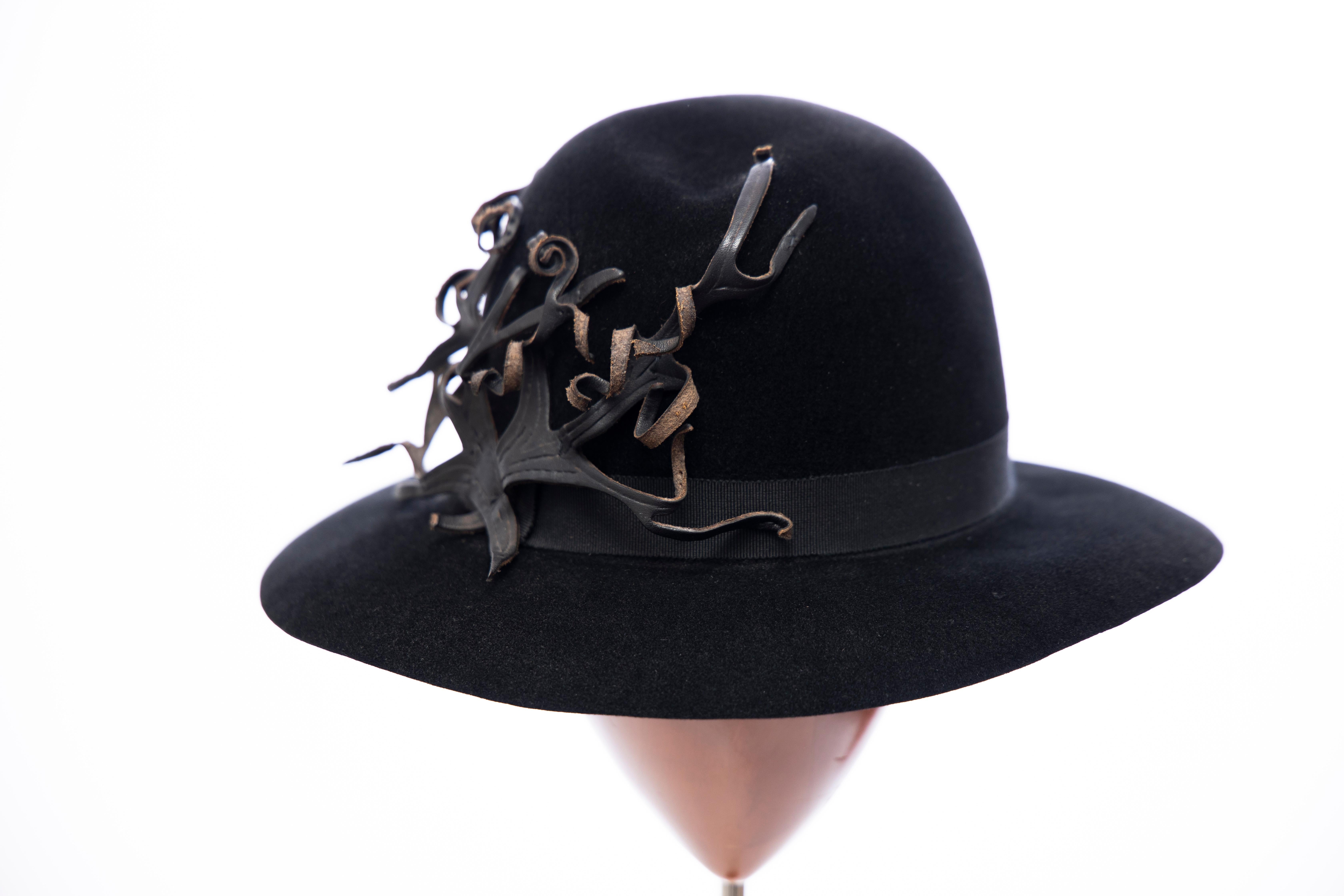 Yohji Yamamoto Pour Homme, ca. 1990's black wool felt fedora hat with black grosgrain ribbon and appliquéd black leather detail.

Circumference: 24.25