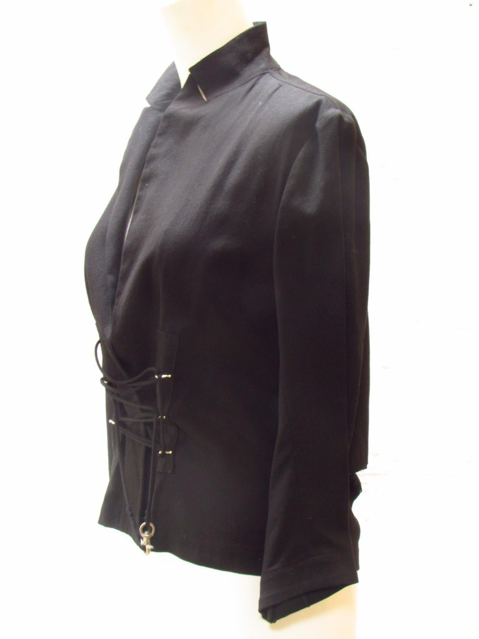 Be a trailblazer in this strapped up black blazer by Yohji Yamamoto. Fabric straps are laced through metal clasps in front and wrap around to tie. Lace cut out panel on back tail and buttoned cuffs finish this magnificent cotton jacket. 