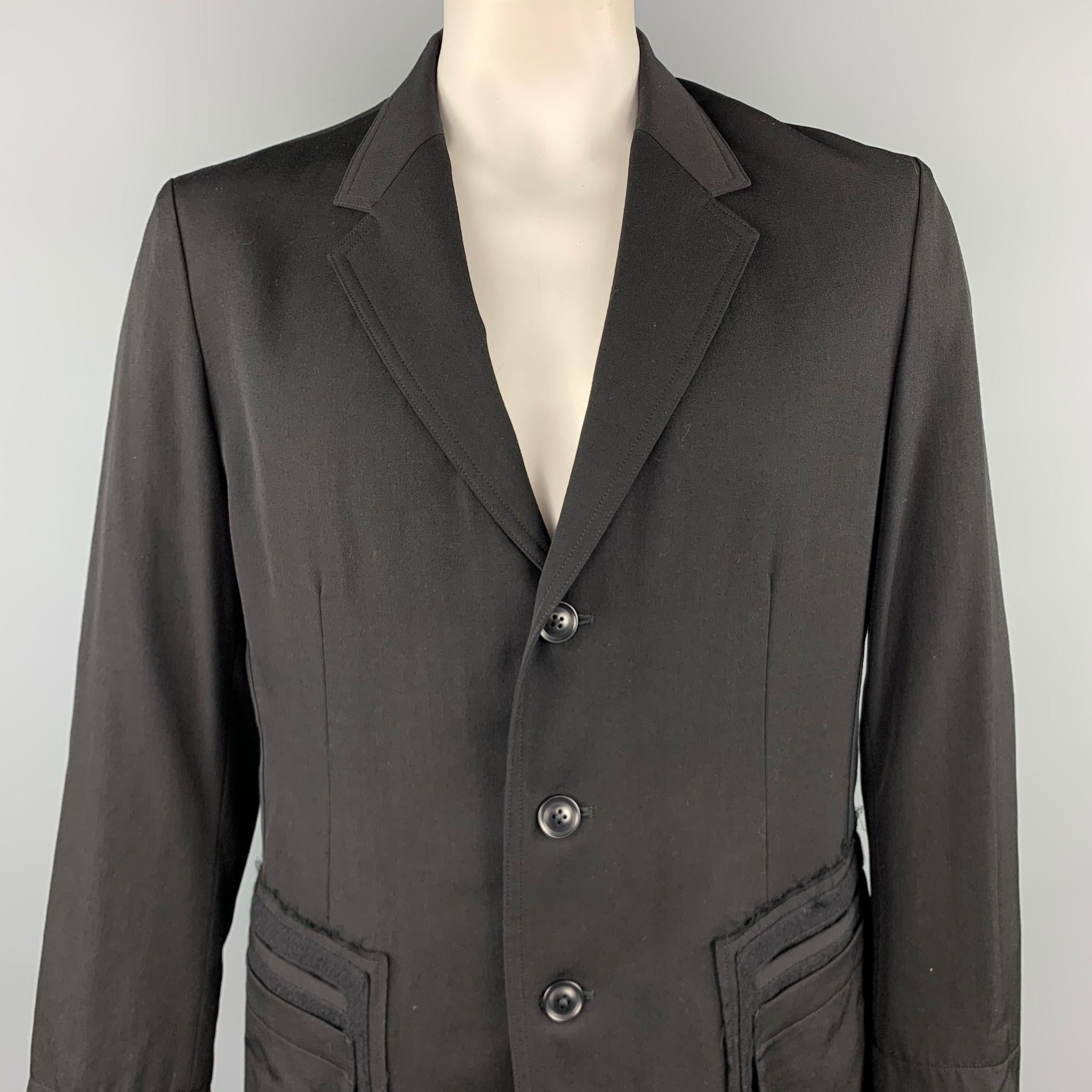 YOHJI YAMAMOTO jacket comes in a black wool featuring a notch lapel, patchwork pockets, raw edge, and a buttoned closure. Made in Japan.

Excellent Pre-Owned Condition.
Marked: JP 4

Measurements:

Shoulder: 19 in. 
Chest: 42 in. 
Sleeve: 25 in.