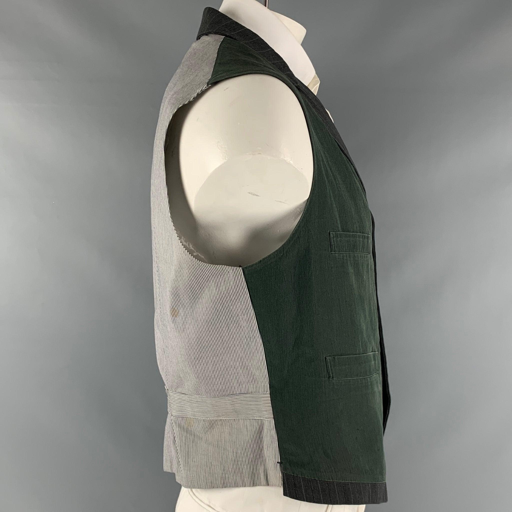 Le gilet Circa'91 de YOHJI YAMAMOTO est réalisé en soie mélangée grise et vert foncé. Il présente des textures mixtes, un revers à cran, des poches passepoilées et une fermeture boutonnée. Fabriqué au Japon. Bon état d'usage. Marques modérées au dos