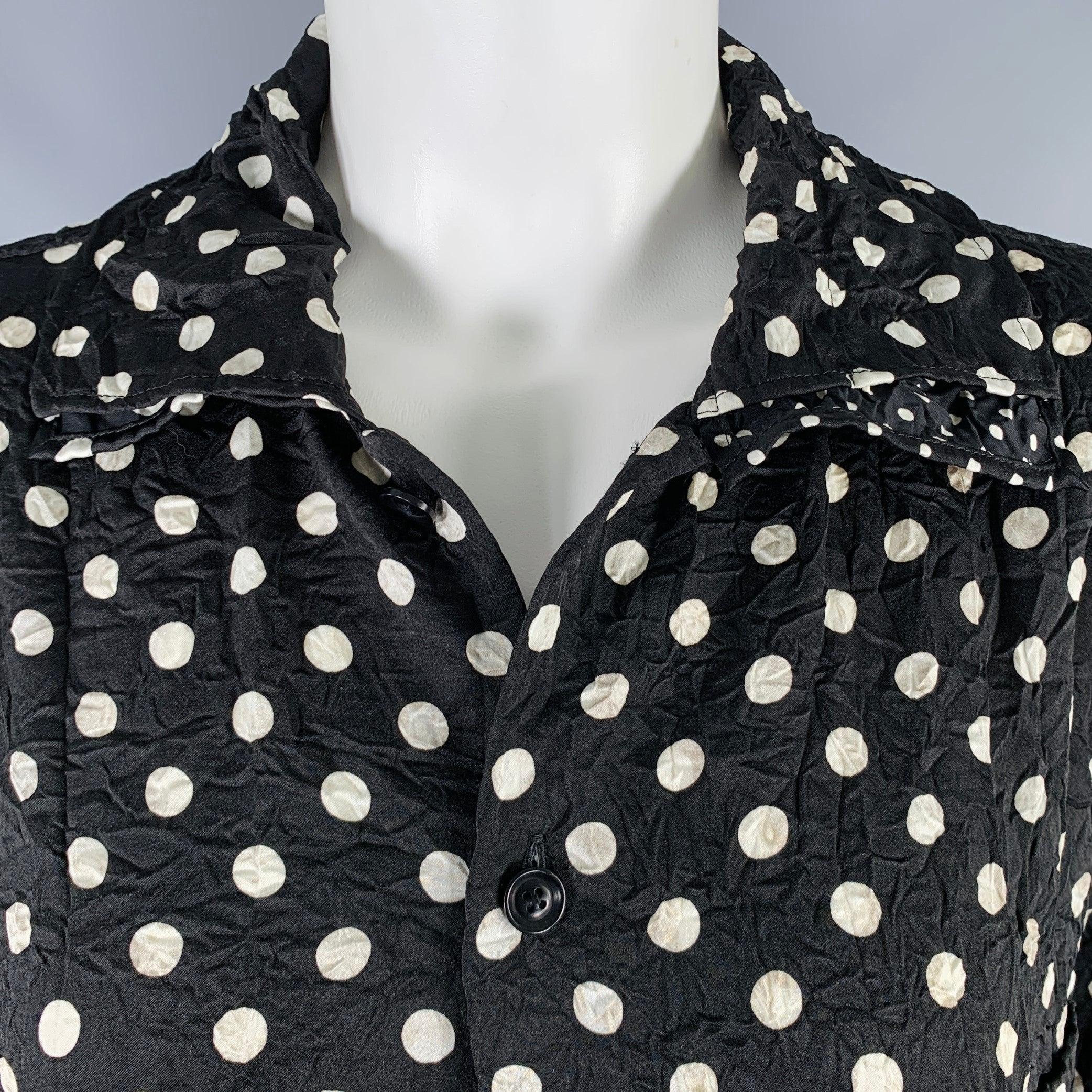 L'abito camicia di Yohji Yamamoto è in tessuto di poliestere stampato a pois bianchi e neri, con colletto asimmetrico a strati, tasca applicata, struttura stropicciata e chiusura con bottoni. Made in Japan.Ottime condizioni di usato. Segni di usura.