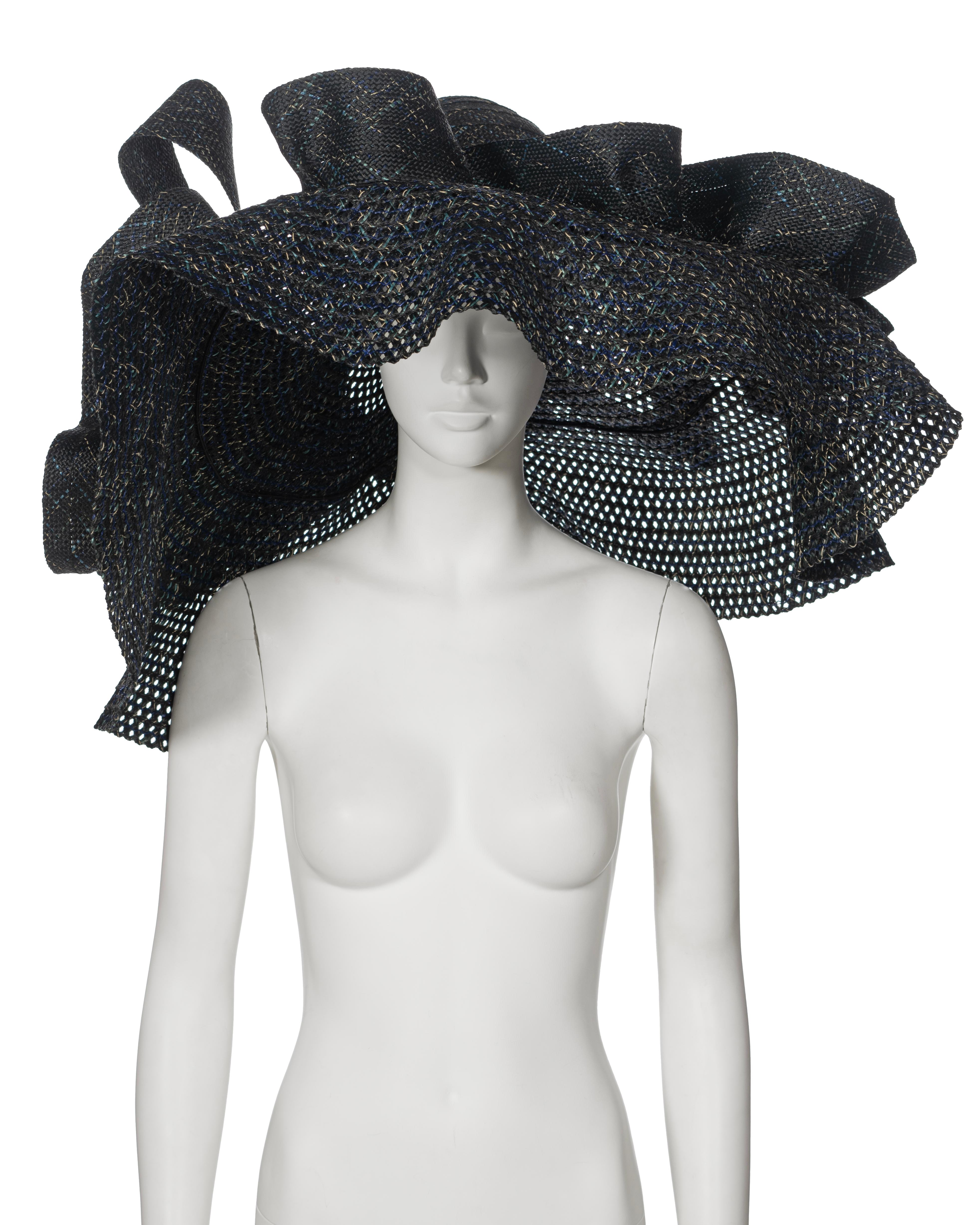 ▪ Archival Yohji Yamamoto Runway Hat
▪ Spring-Summer 1988
▪ Sold by One of a Kind Archive
▪ Woven raffia in black, blue, turquoise, and cream shades
▪  Extra-wide floppy brim, measuring up to 92cm in diameter
▪ Large hand-sewn self-fabric ruffles
▪