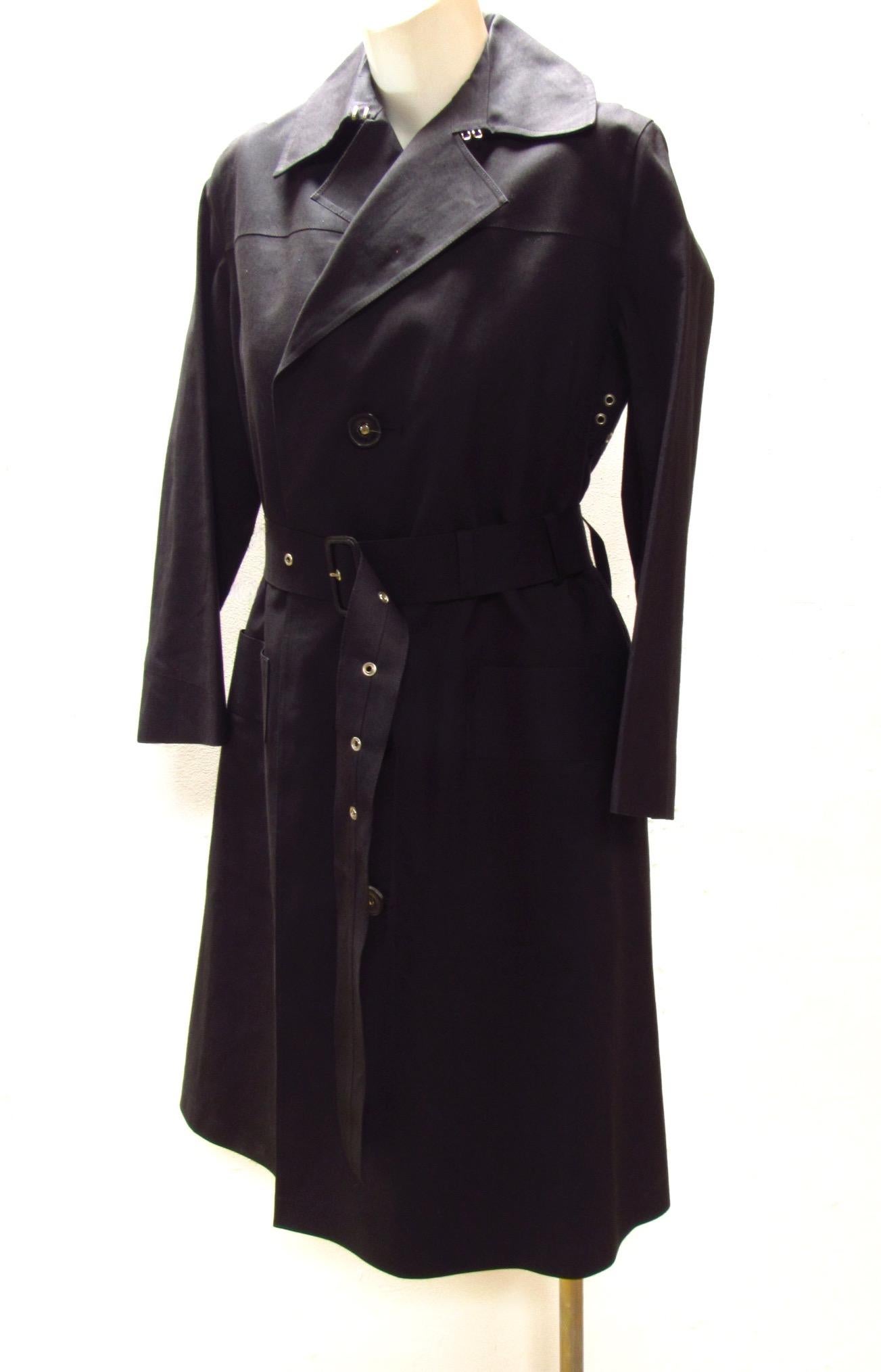 Black cotton belted button-down raincoat from vintage Y's is lined with a 100% wool detachable lining and offers hook and eye fasteners at collar to keep you cozy when the weather won't. Two front pockets.