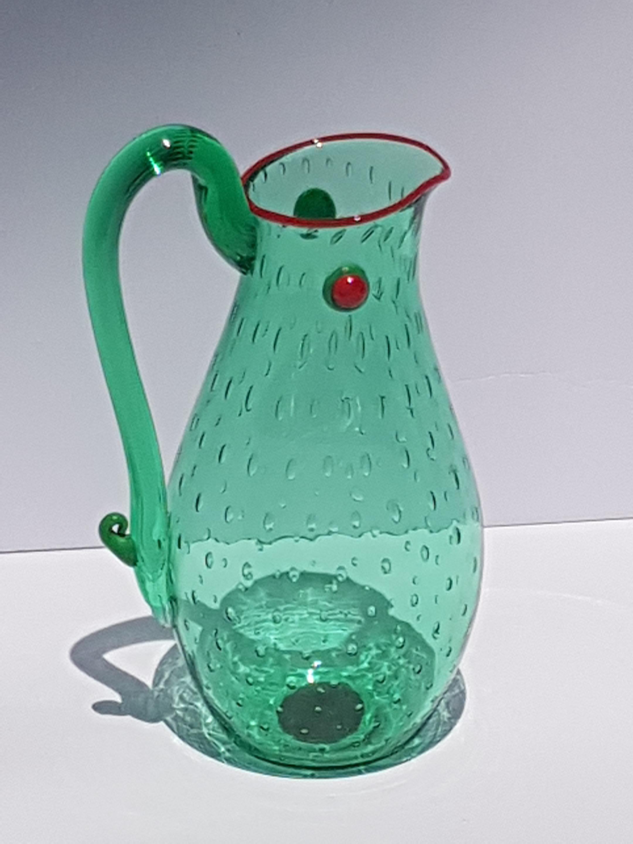 An exquisite art glass vessel by Yoichi Ohira signed Y. Ohira L. Serena 1995 Murano. Crafted in translucent emerald green glass with controlled air bubbles and red pasta type accents. This elegant vessle can be used as a vase, ewer/pitcher or as a