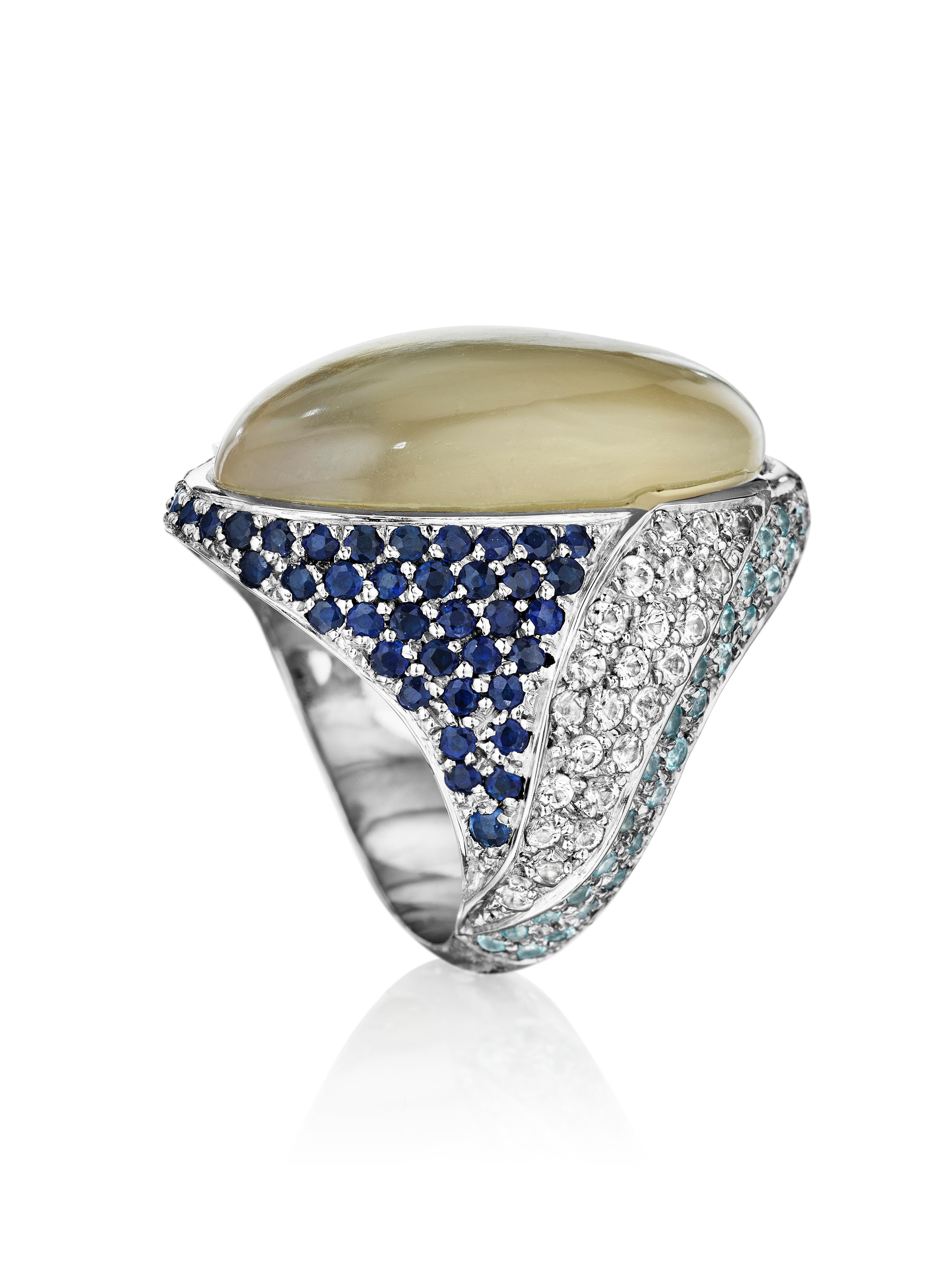 Inspired by coastline and view of the ocean waves under the winter sky. Ring features Grey Moonstone, Blue Sapphires, Aquamarines, and White Sapphires set in 18k white gold. 

Size 7.5 

Dimension:  2.0cm face width, 2.8cm face length