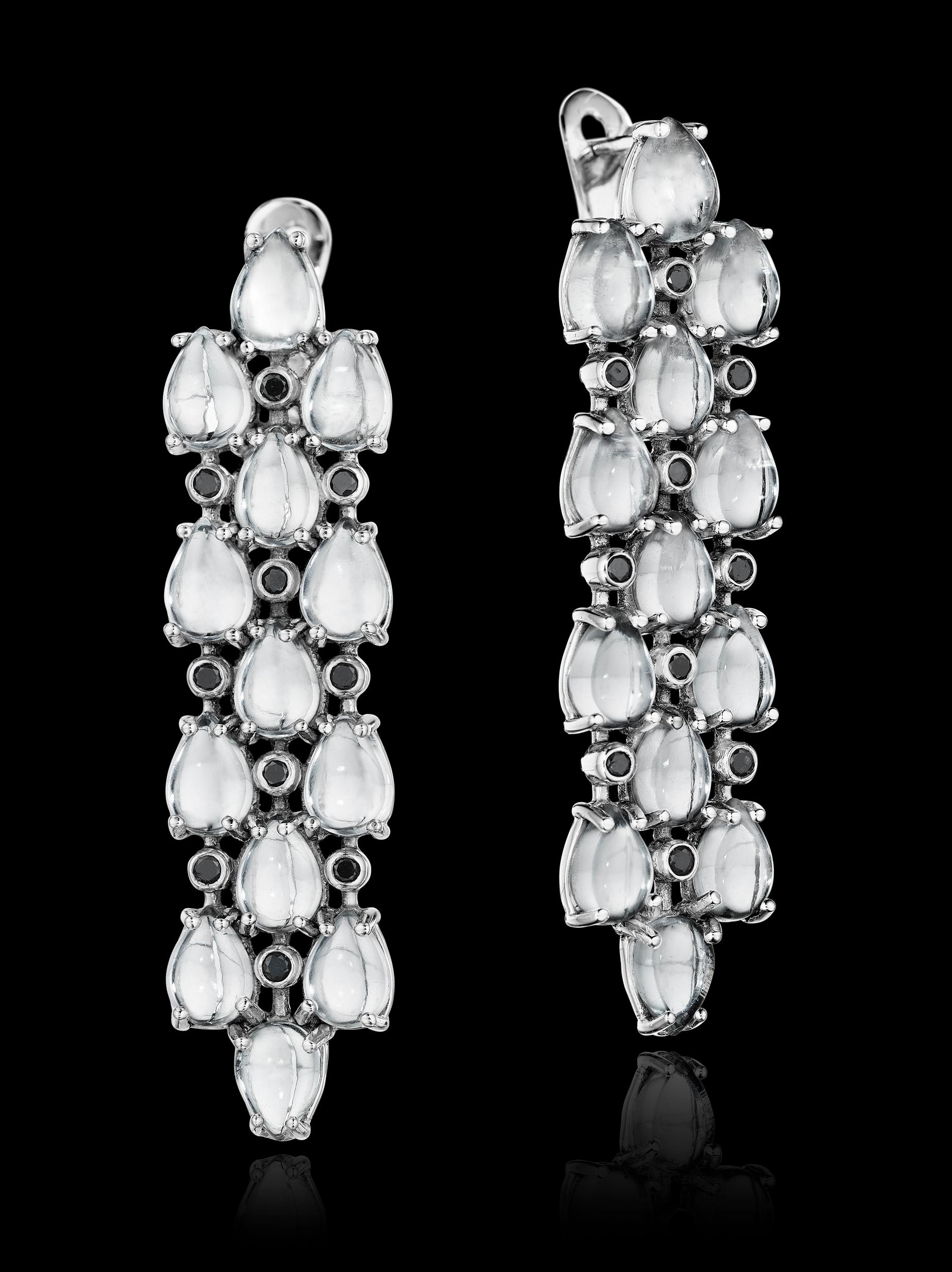 Limited edition YOKI design, features 26 5x7mm Cabochon Pear Shaped White Topaz approx. 27.1cts. Total Black Diamond weight is approx. 0.3cts. Earrings are set on 18 karat white gold. Earring measures approx. 1.2cm face width across and 5.1cm face