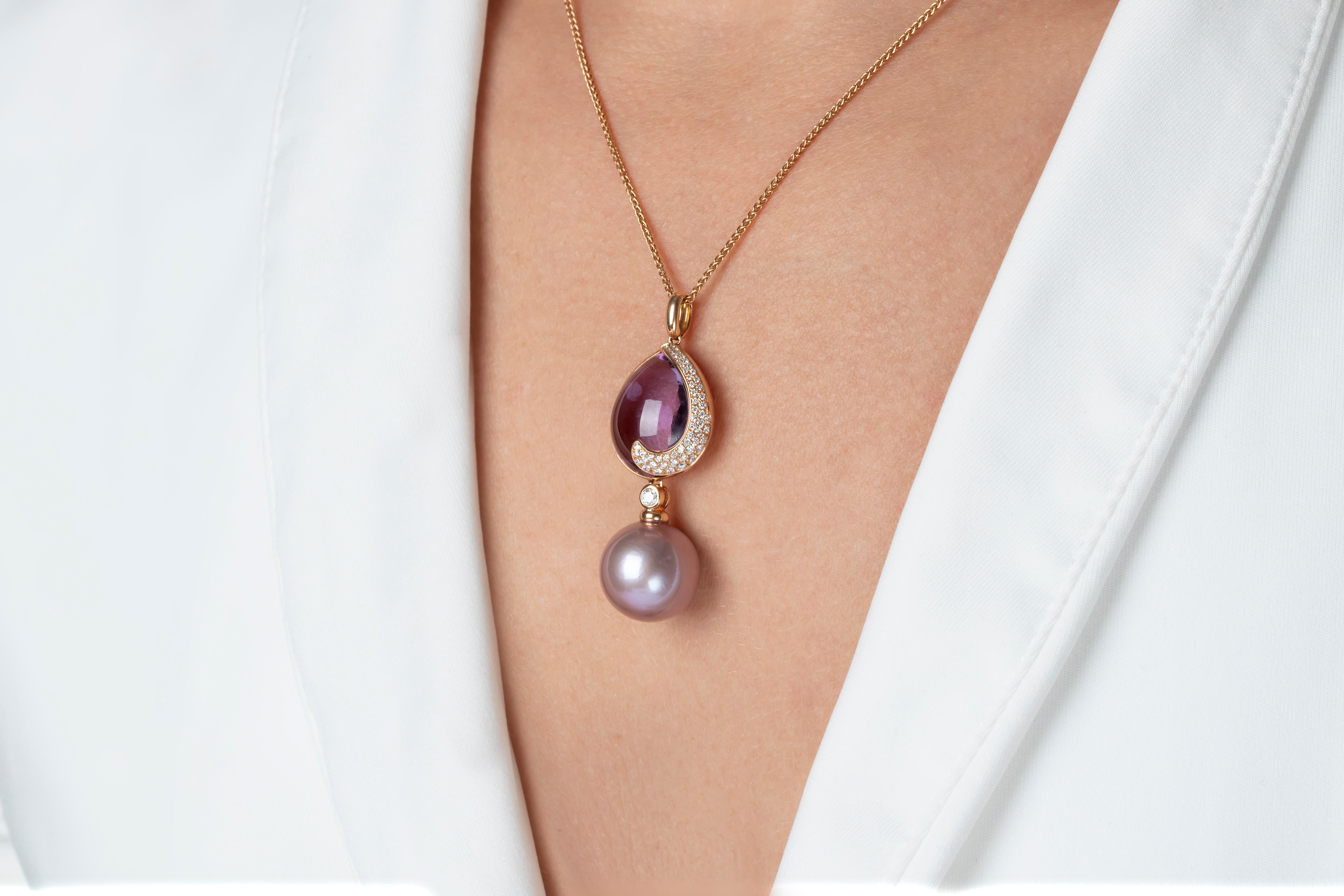 This bold pendant features a pretty amethyst cabochon in within a swirl of sparkling white diamonds, accentuated by a rare natural colour pink pearl. This delightful necklace will add a sumptuous pop of colour to any outfit it is combined
