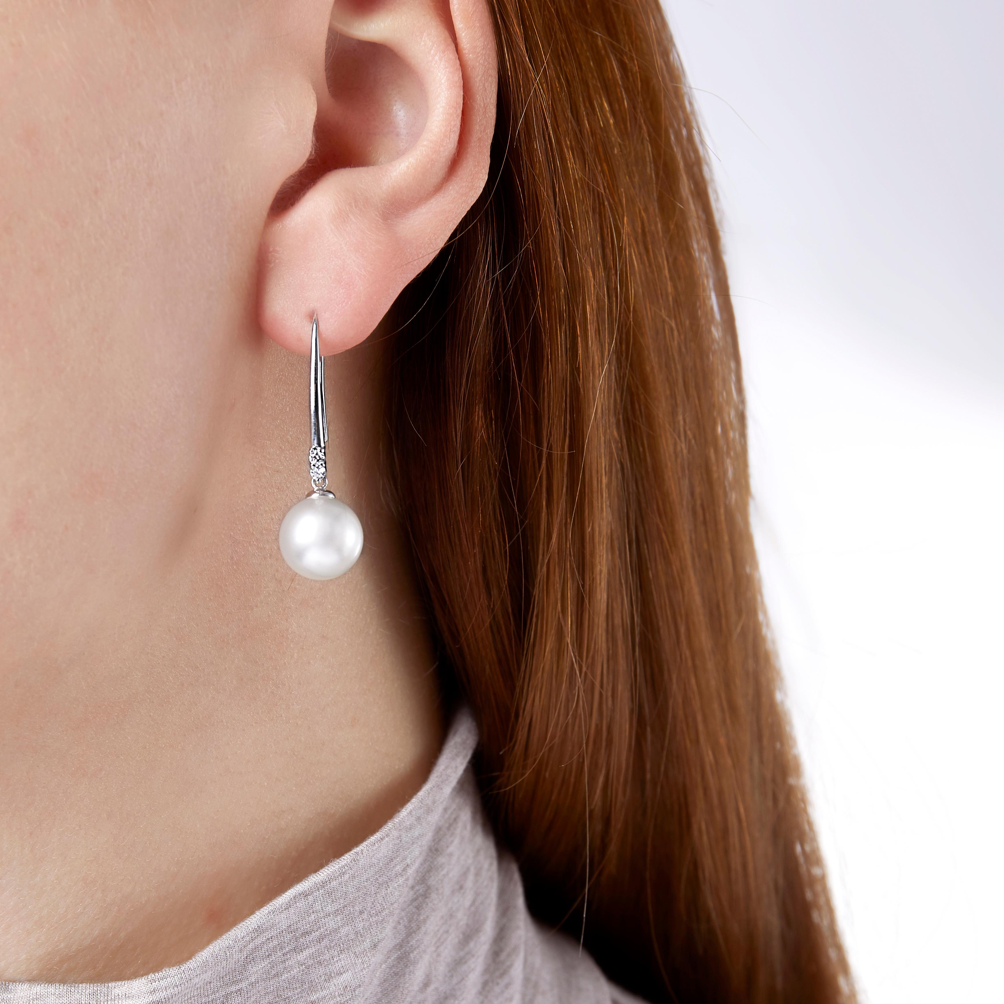 Graceful and delicate, these pretty earrings by Yoko London feature a lustrous South Sea pearl suspended from a stylised hook earring fitting set with diamonds. The hook fitting is perfect for those who struggle with conventional earring backs.