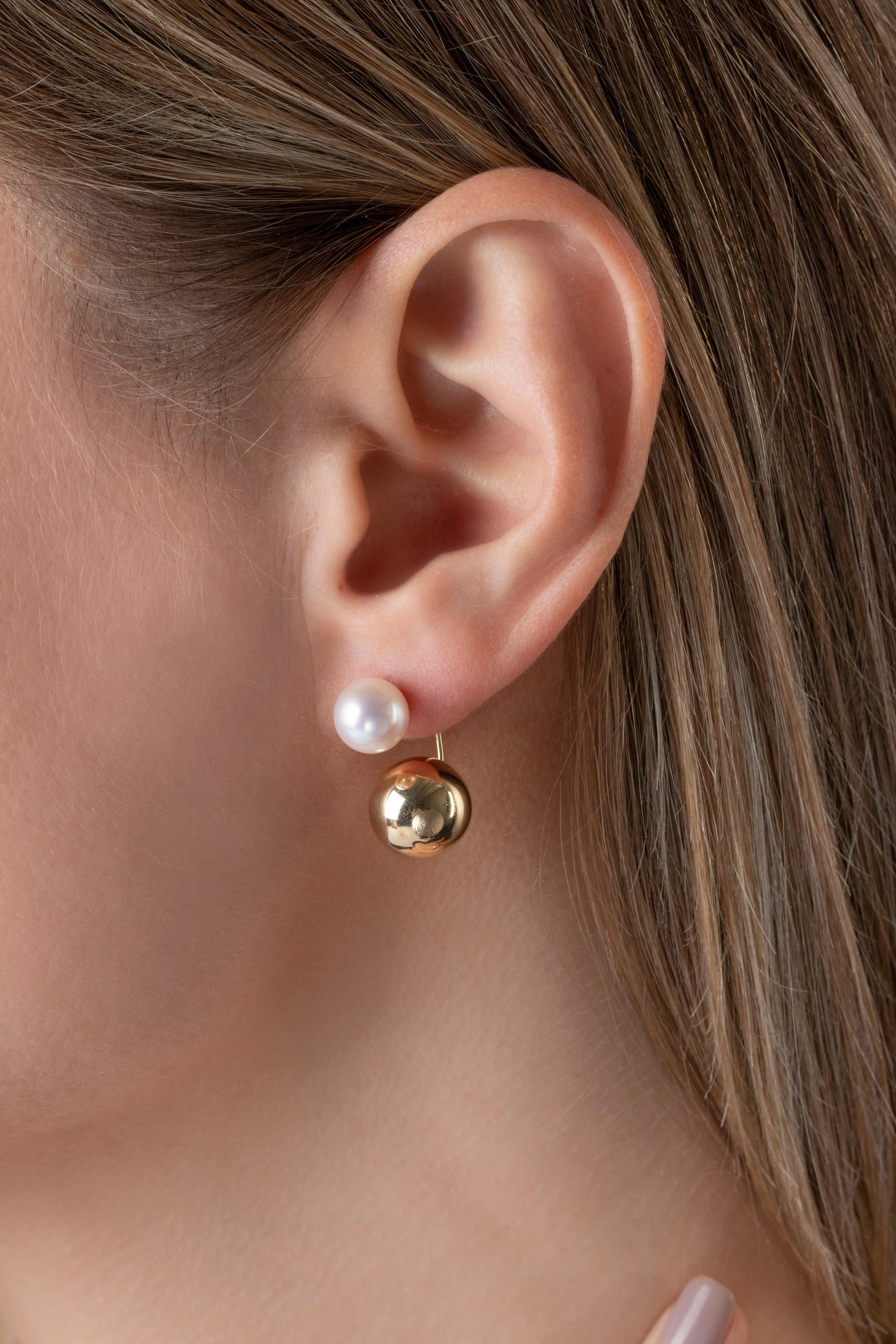 These striking earrings by Yoko London feature lustrous Akoya pearls atop a yellow gold sphere which sits beneath the lobe. Contemporary and elegant, these unique earrings will add a striking touch to any outfit.  
-8-8.5mm Japanese Akoya Pearls
