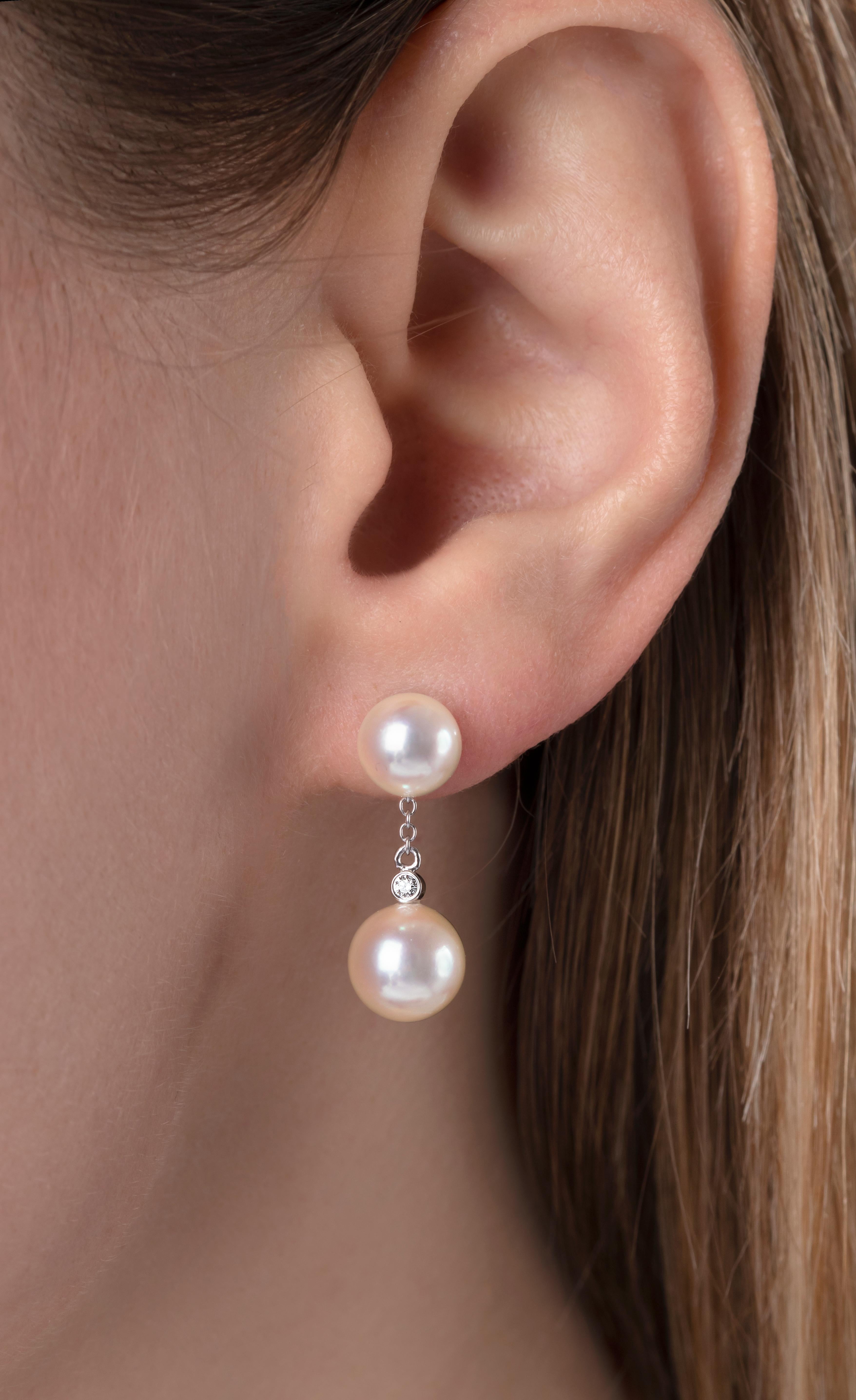 These elegant earrings feature lustrous, high quality Akoya pearls, accentuated by an 18 Karat white gold chain and scintillating solitaire diamonds. Embodying the timeless qualities of a classic pearl stud, whilst simultaneously adding a