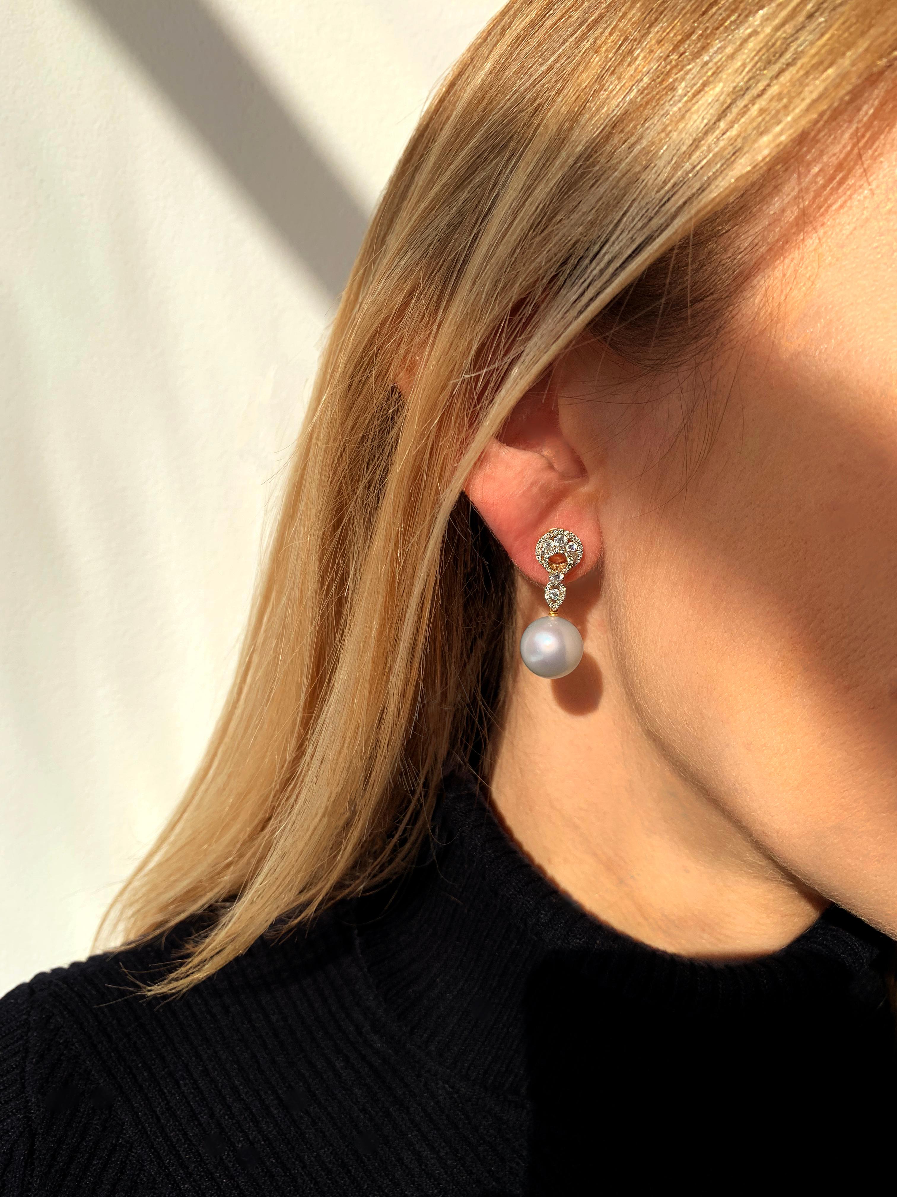 These scintillating earrings by Yoko London feature lustrous South Sea pearls beneath an elegant arrangement of diamonds. The 18 Karat yellow gold setting serves to enrich the radiance of the diamonds and the crisp white lustre of the South Sea