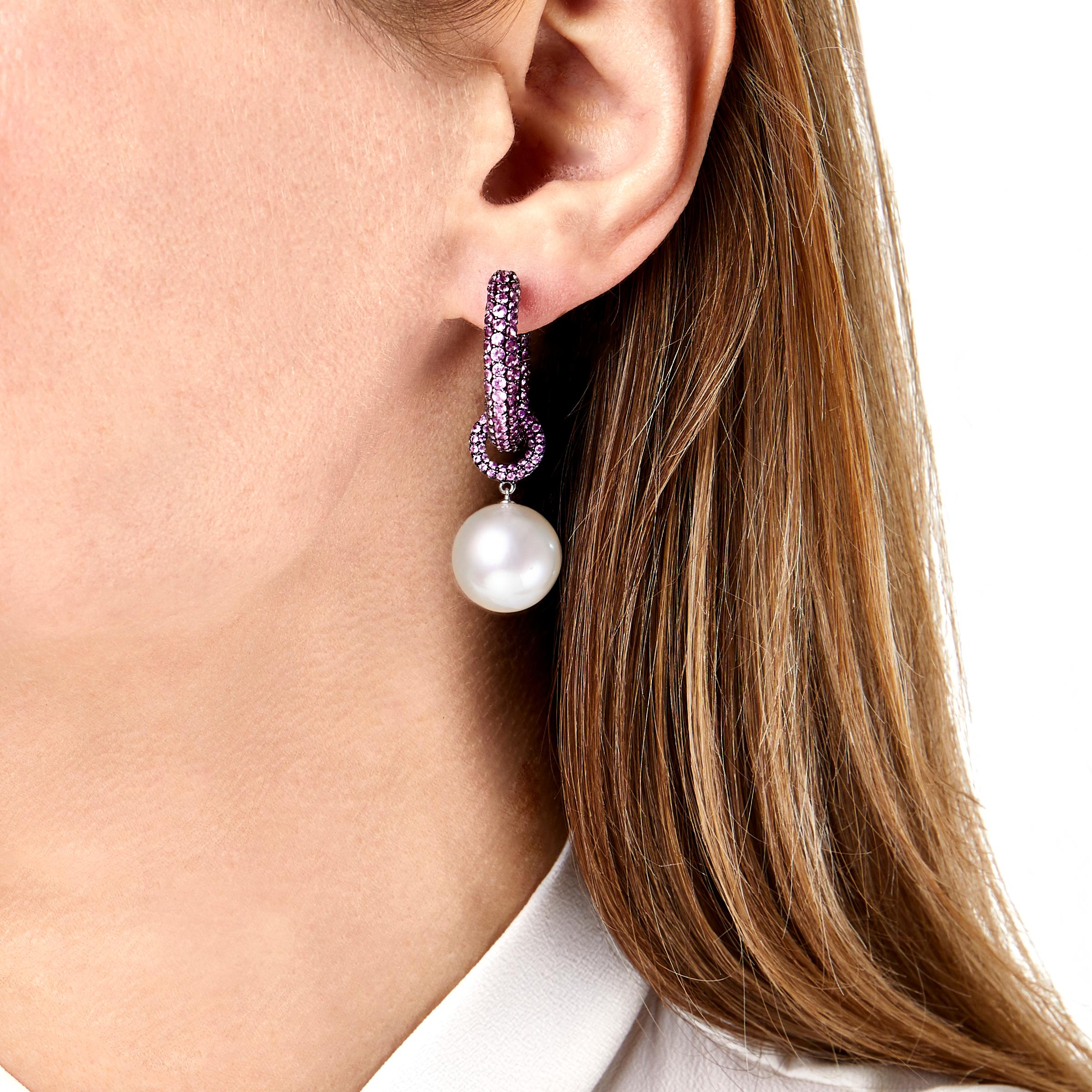 These Yoko London earrings are a beautiful fusion of modern fashion and precious gemstones. Featuring 10.49ct of Pink Sapphires with 14-15mm Australian South Sea Pearls, these hoops will make a unique centerpiece to your jewelry box. The pearl drop