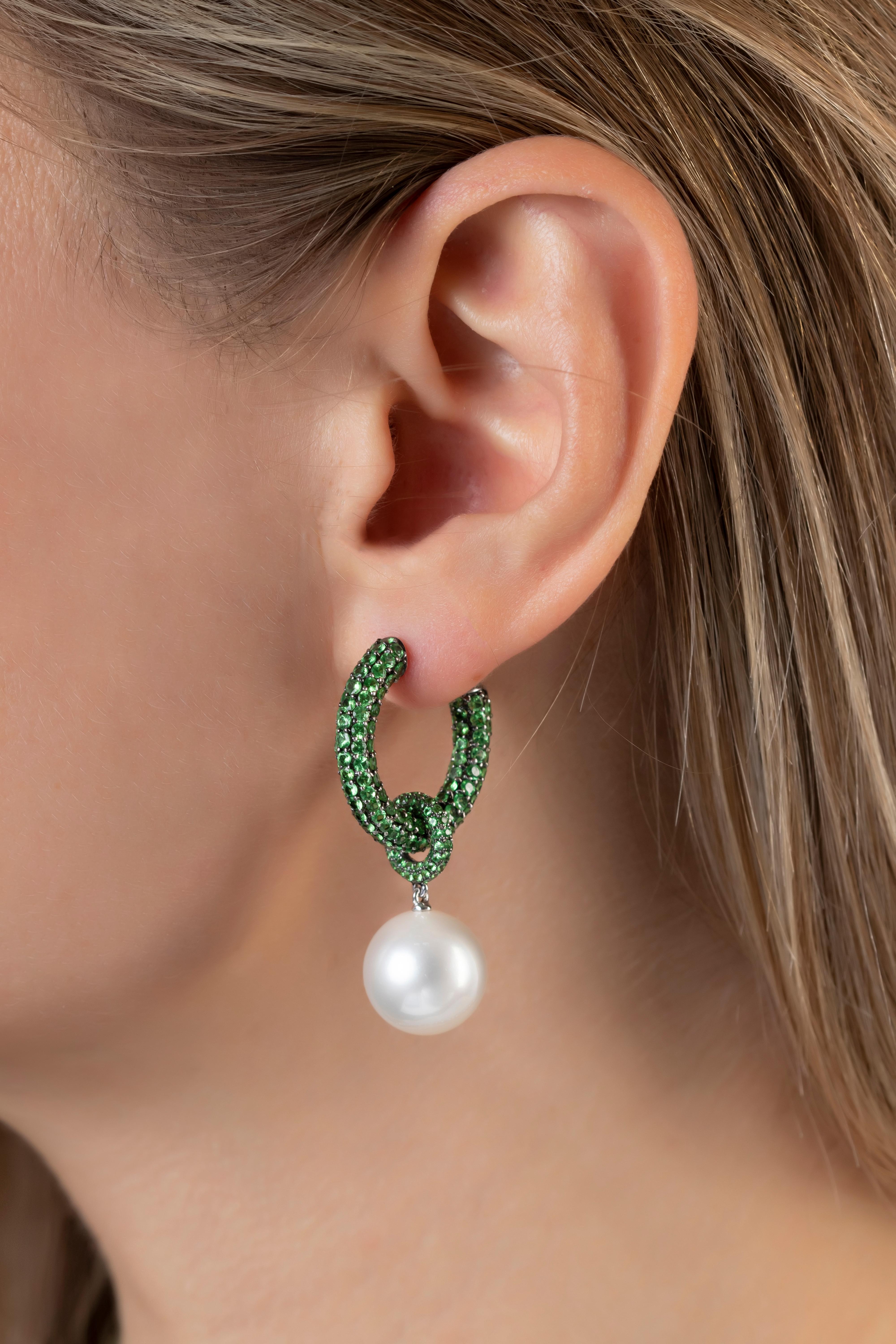 These unique earrings by Yoko London feature lustrous South Sea pearls beneath a mesmerising hoop of green tsavorite garnets. For added versatility the pearl can be removed allowing the hoop of green garnets to be worn alone. A truly striking and