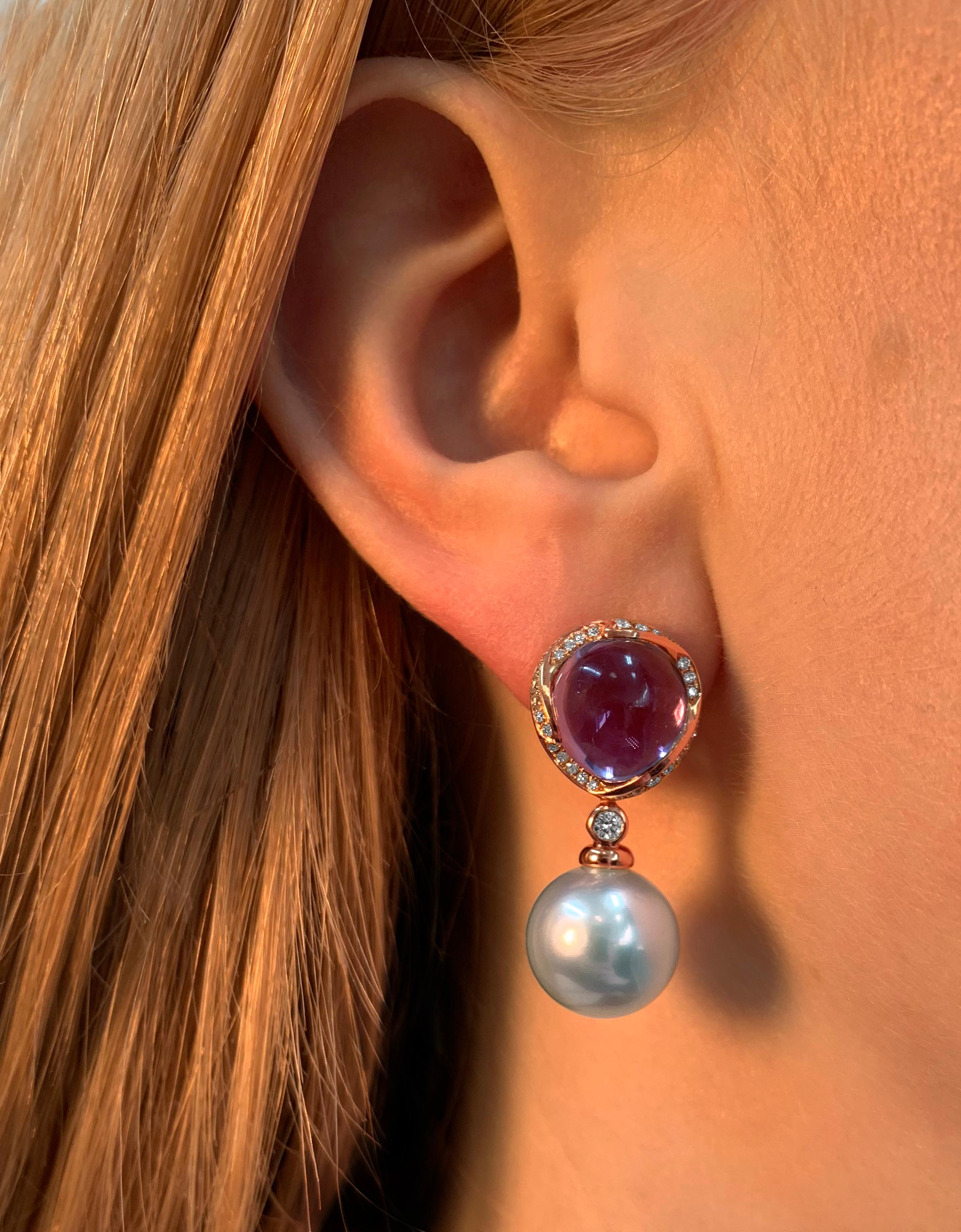 These elegant earrings by Yoko London feature lustrous South Sea pearls beneath mesmerising cabochon cut amethysts. Set in 18 Karat yellow gold to enrich the vibrant hues of the amethyst, these captivating earrings add a sumptuous touch of colour to