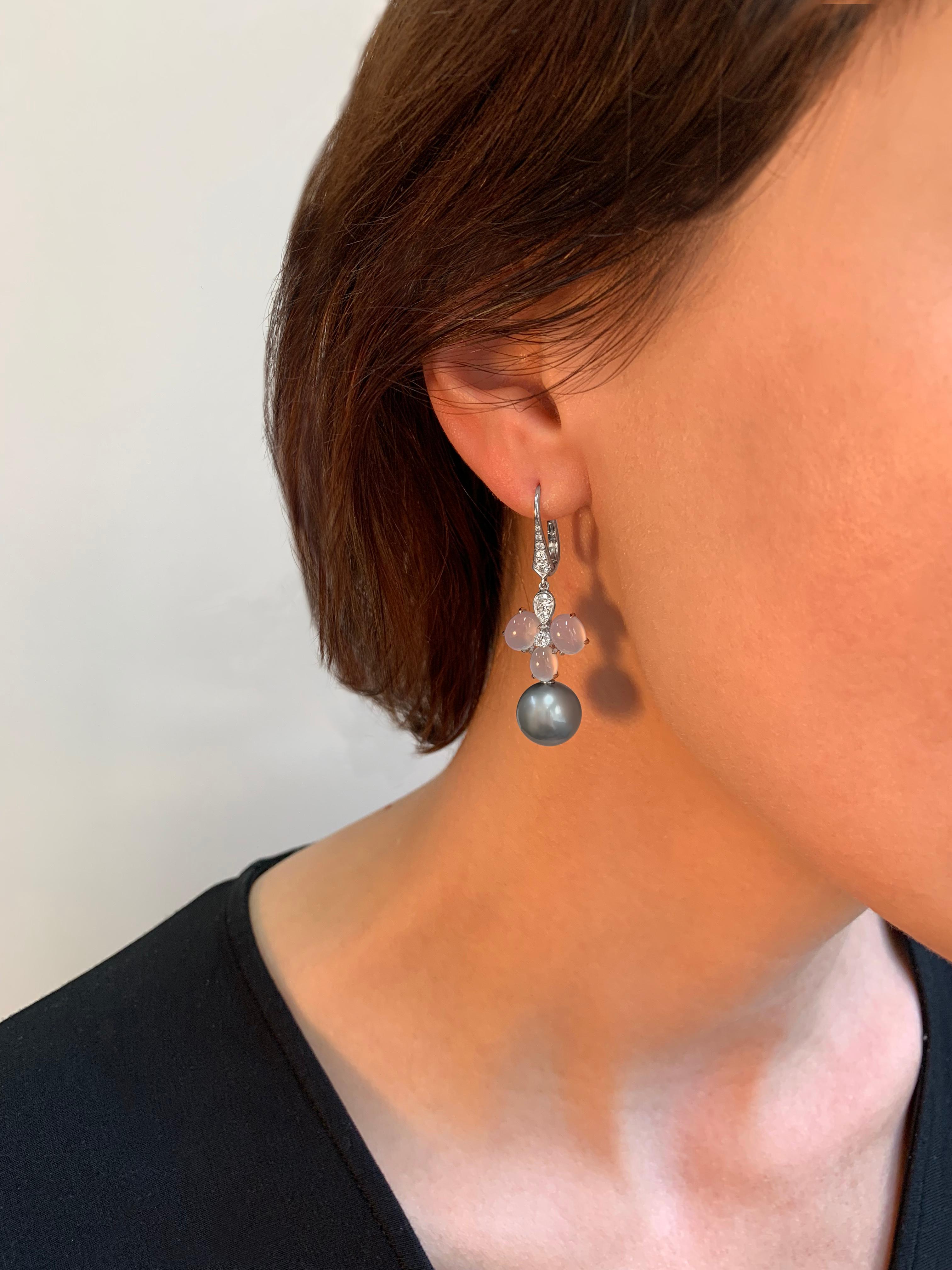 These lovely earrings by Yoko London feature Diamonds and Chalcedony that form a fun floral design. The lilac hues of the Chalcedony compliment the cool grey tones of the Tahitian pearl perfectly. These colours are enriched further by the muted 18