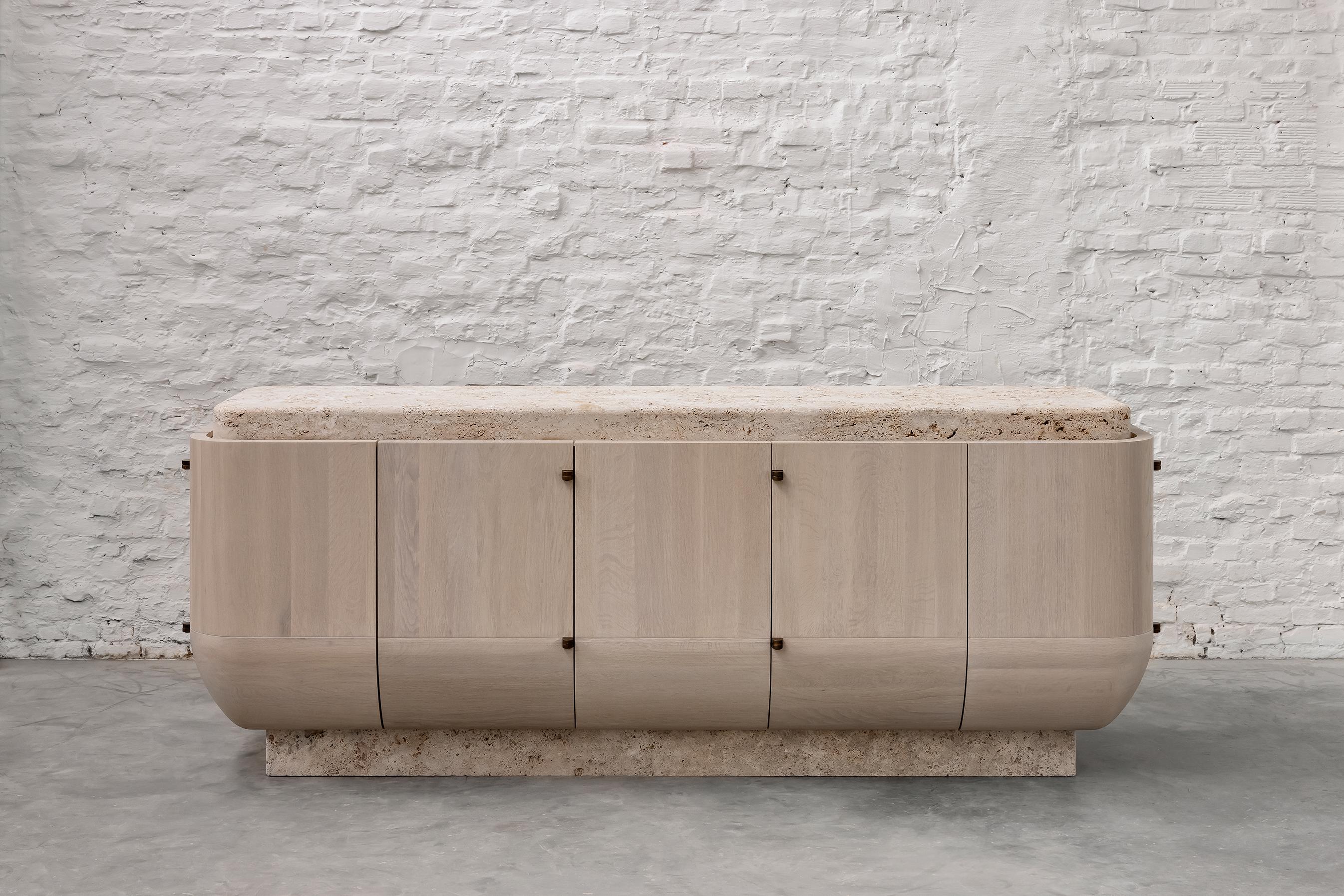 Yoma Console by Andy Kerstens.
Limited Edition of 20 
Dimensions: W 255 x D 70 x H 100 cm
Materials: Wood bleached and brushed European oak, solid + veneer
Metal solid brass with patinated bronze finish, Stone cross-cut open pore travertino