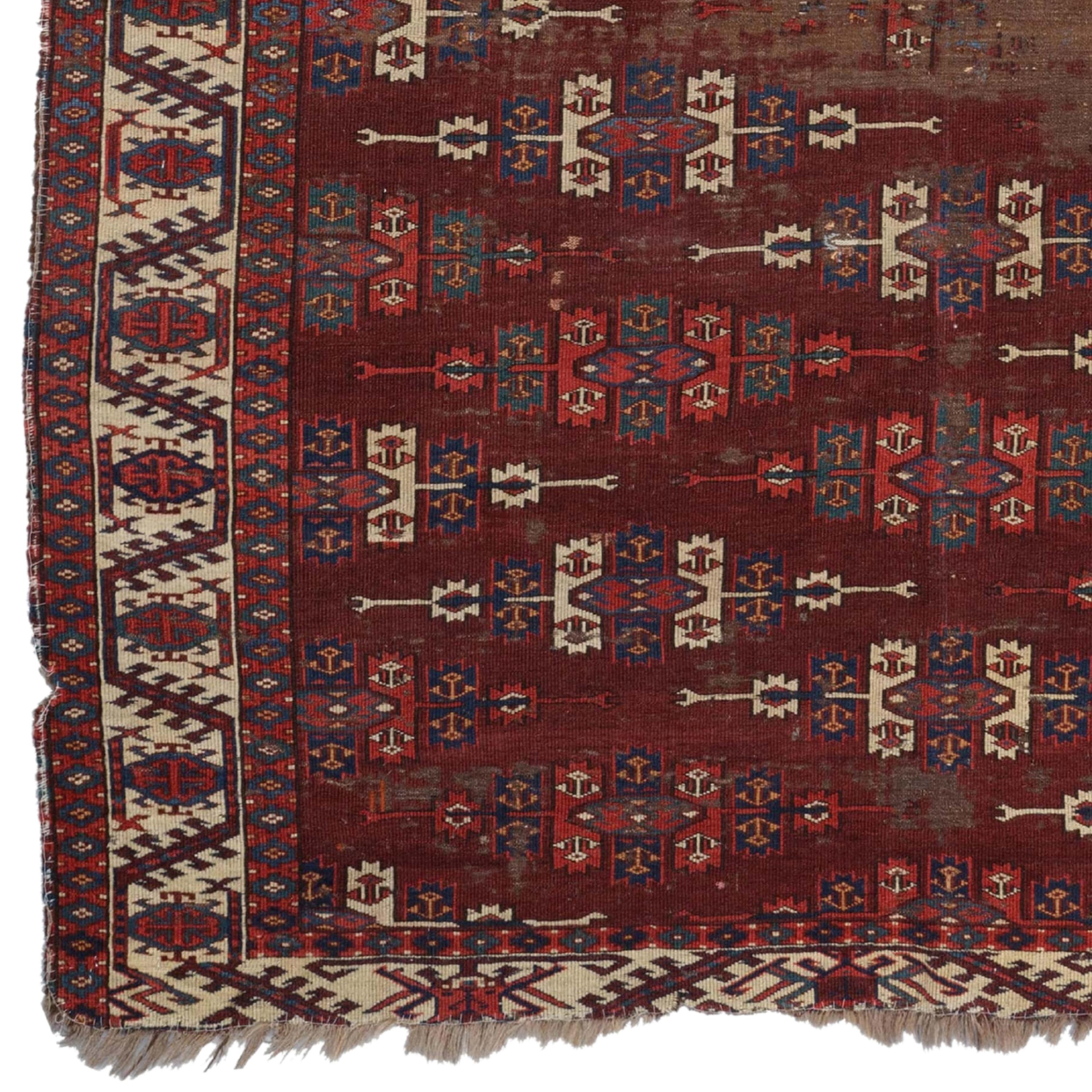 This elegant 19th century Yomud Dyrnak Gul carpet attracts attention with its historical texture and unique patterns. This hand-woven rug in rich shades of red and brown is a perfect example of authentic Yomud design. Each corner of the antique