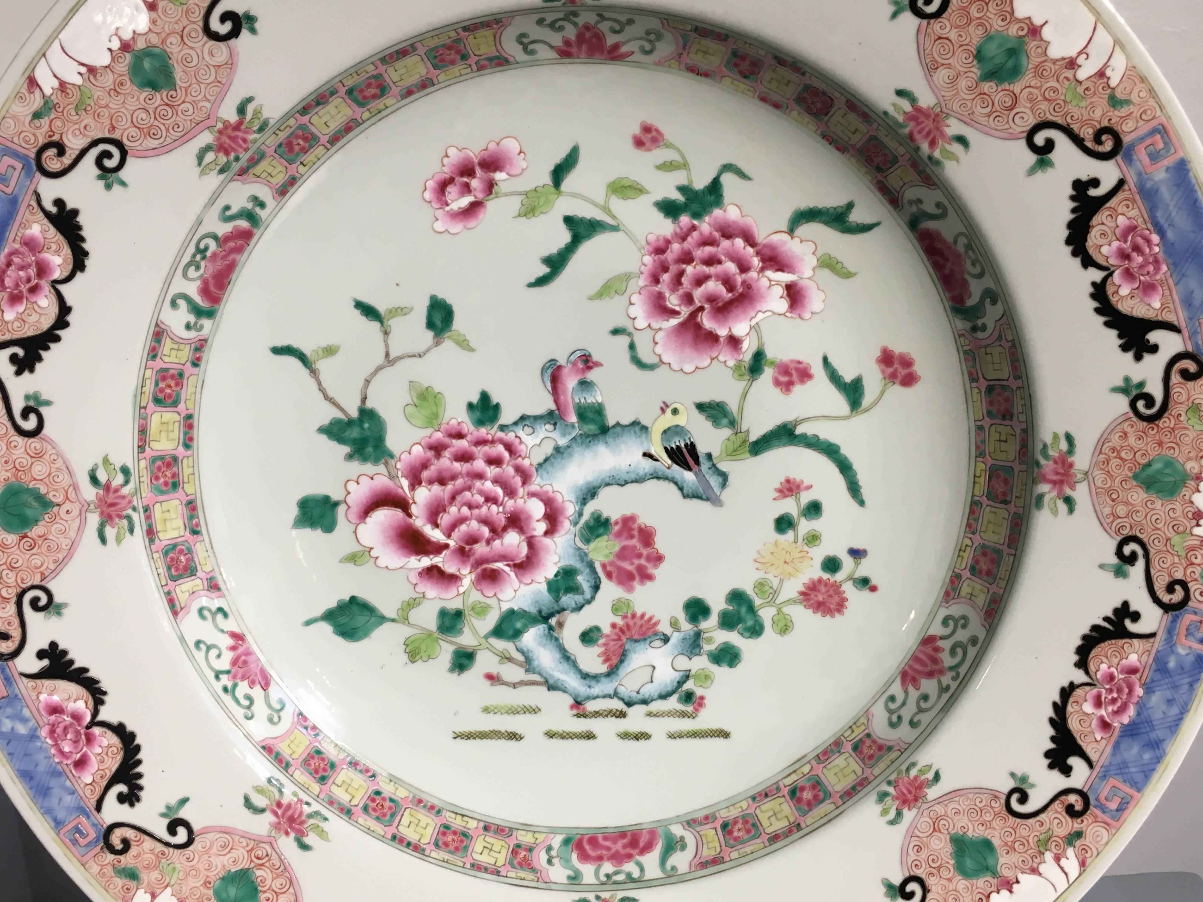 A large Yongzheng style Chinese porcelain charger decorated in beautiful famille rose enamels of pinks, blues, greens and yellows, 20th century, China. 

Painted in the Chinese export manner with famille rose enamels in the Yongzheng color palette,
