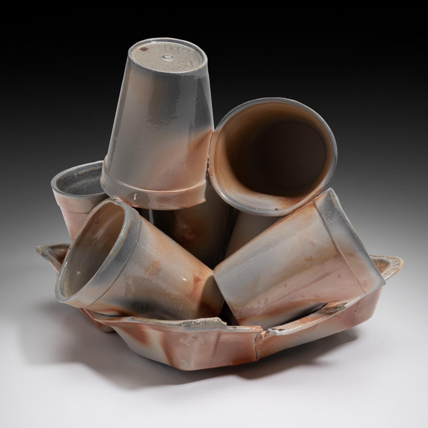 "Restos (Pila de tazas)", escultura en madera cocida de tazas equilibradas para llevar