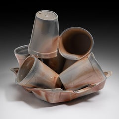 "Restos (Pila de tazas)", escultura en madera cocida de tazas equilibradas para llevar