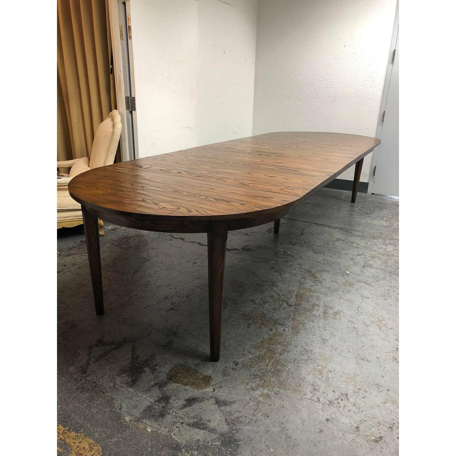 A Yorkshire House dining table. This gorgeous solid oak table was handcrafted in Vermont. The table has the capability to grow from a 48 inch round to 114 inch oval. The table and the leaves have stunning hand scraped finish which gives the table