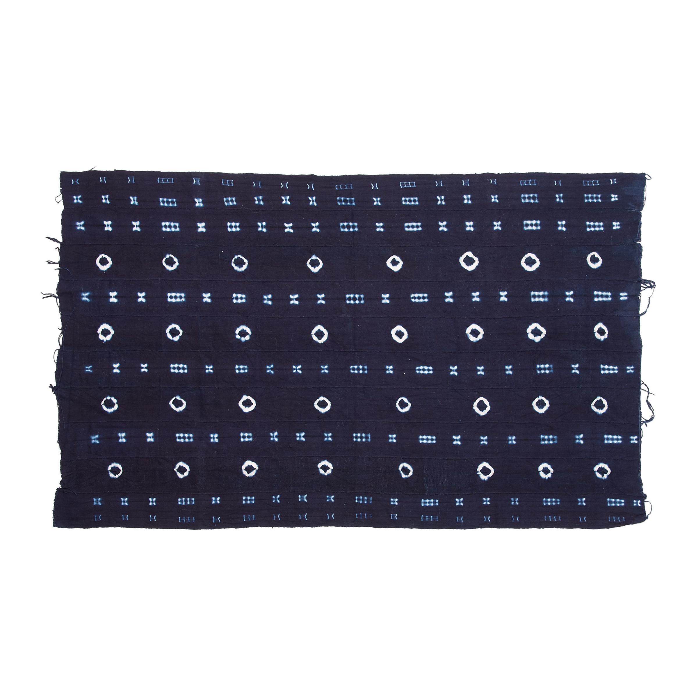 A vibrant and beautifully irregular pattern covers this indigo textile by the Yoruba People of Nigeria. Hand-dyed by women, this style of tie-resist indigo cloth is known as Adire Oniko and is achieved by tightly tying up portions of the strip-woven