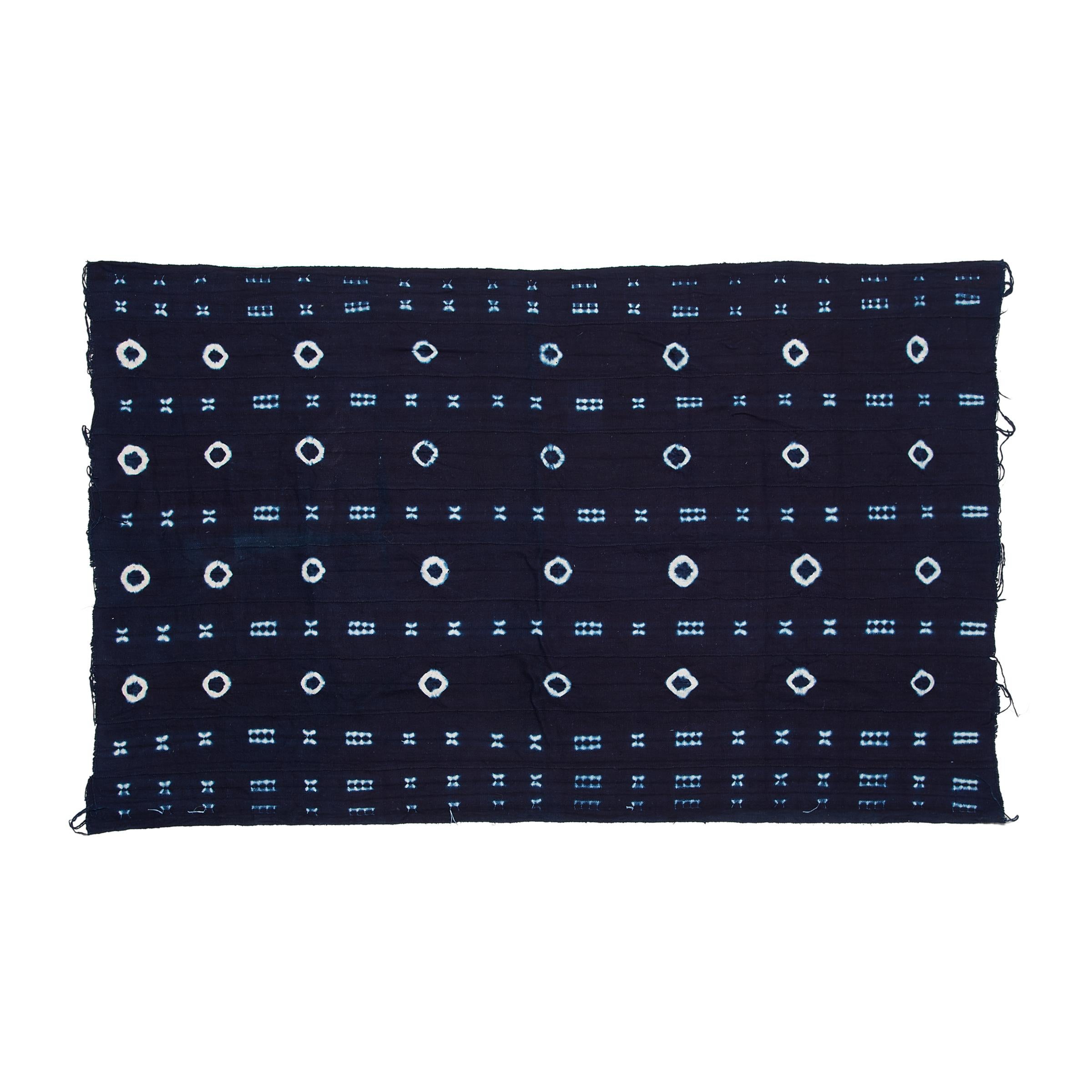 A vibrant and beautifully irregular pattern covers this indigo textile by the Yoruba People of Nigeria. Hand-dyed by women, this style of tie-resist indigo cloth is known as adire oniko and is achieved by tightly tying up portions of the strip-woven