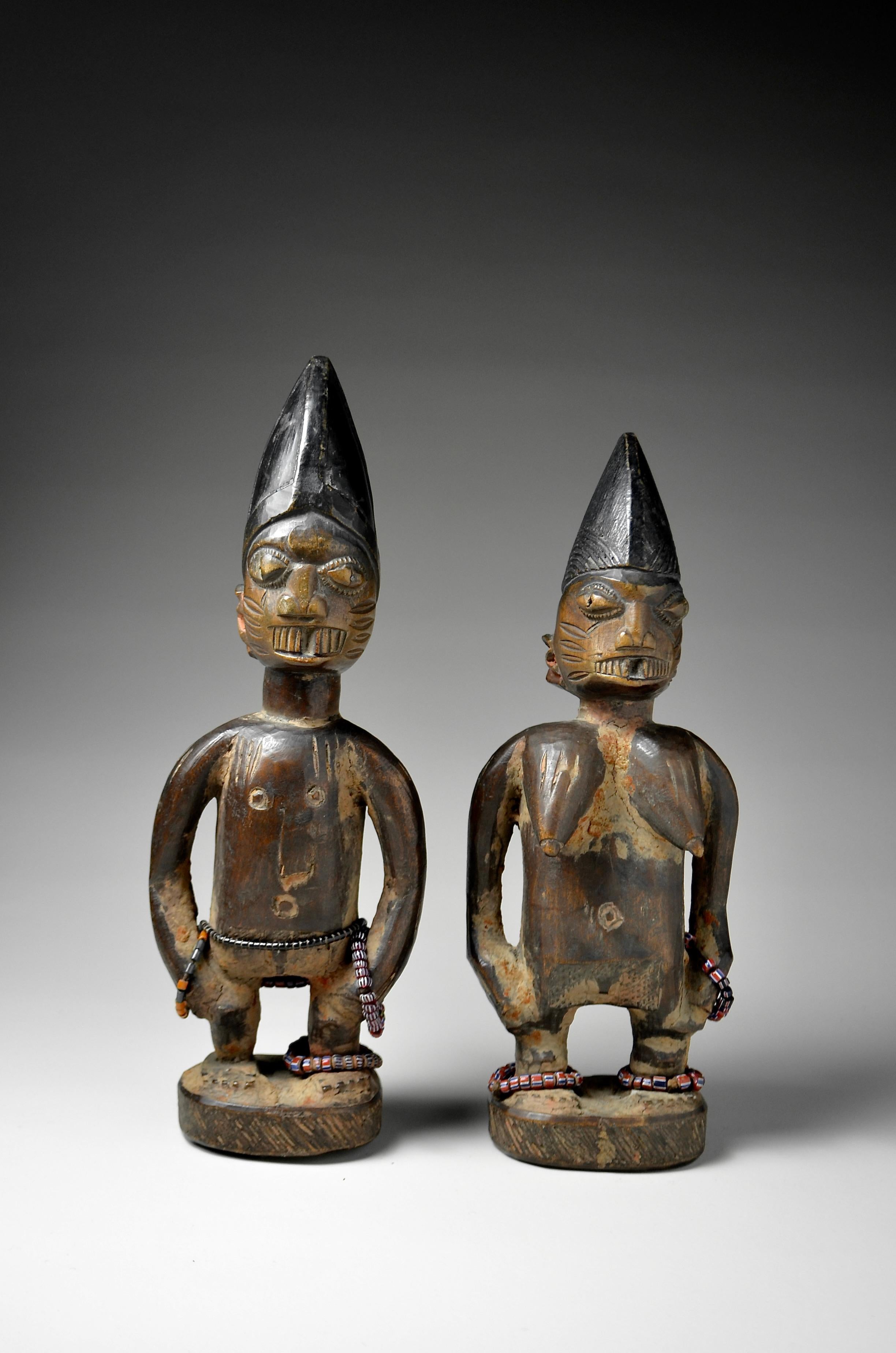 Ibeji pair
Ajasse
Nigeria 
Wood, beads, pigment, offering remains
26.5cm and 25cm

ex Beatrice Leutert and Marcel Plüss collection, Thurgau, Switzerland