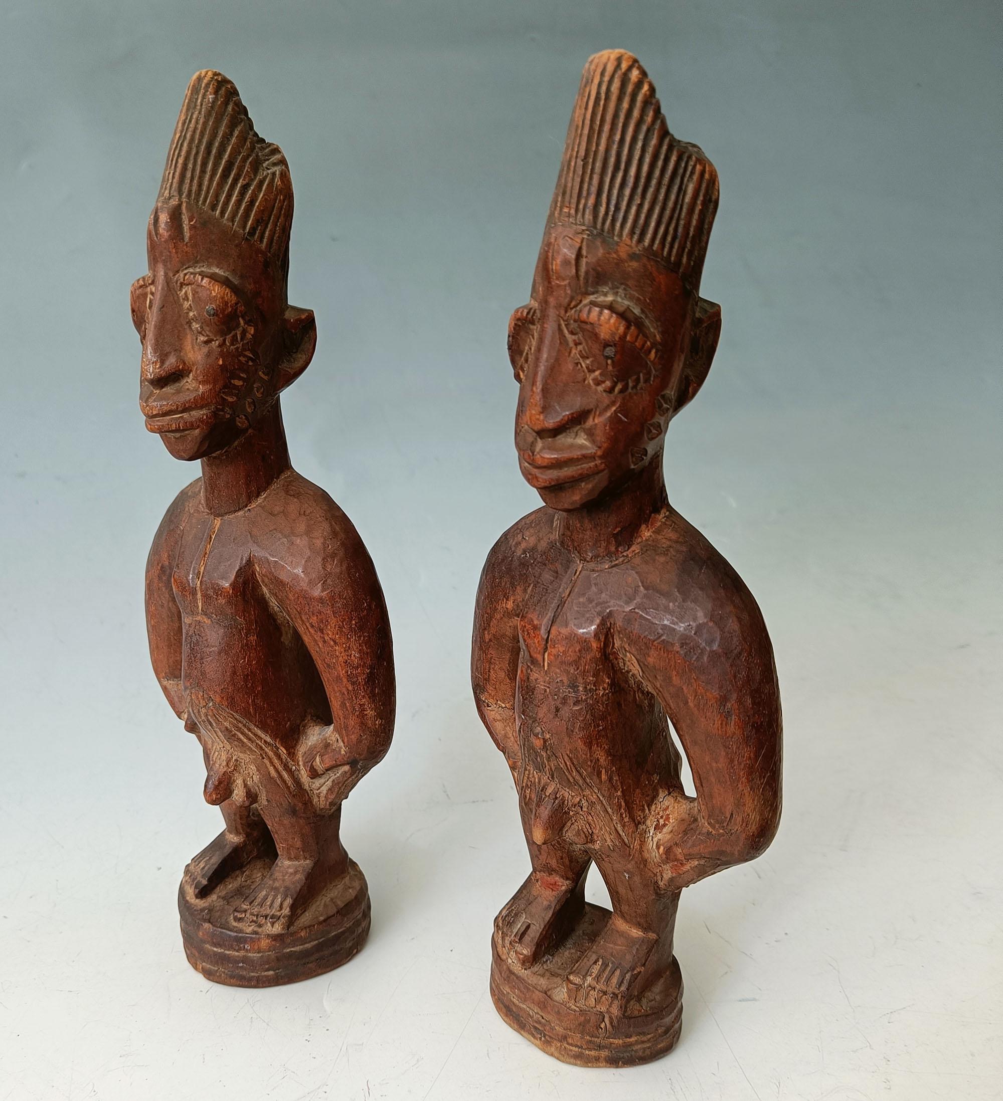 Afrikanische Stammeskunst.
Schönes altes männliches und weibliches Paar Yoruba Ibeji-Figuren aus der Igbuke-Schnitzwerkstatt in Oyo. 
Igbuke war ein bekannter Schnitzer von Ibeji-Figuren, und dieser Stil wird seiner Werkstatt zugeschrieben 
Maße: