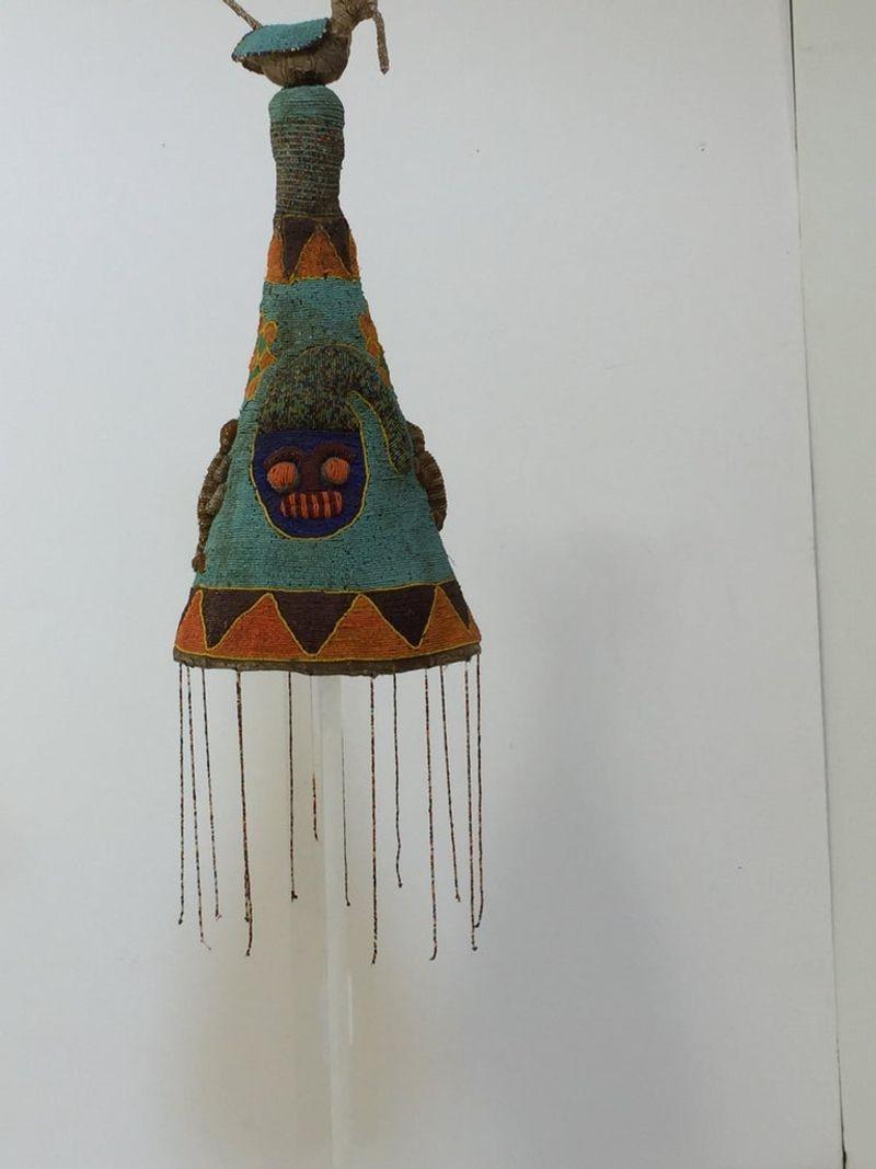 West African hand beaded head dress crown from Yoruba, Nigeria.
This artistic beautiful and functional art piece is covered with beads in turquoise, orange, green, yellow red, blue and black colors with a face in front and ten birds