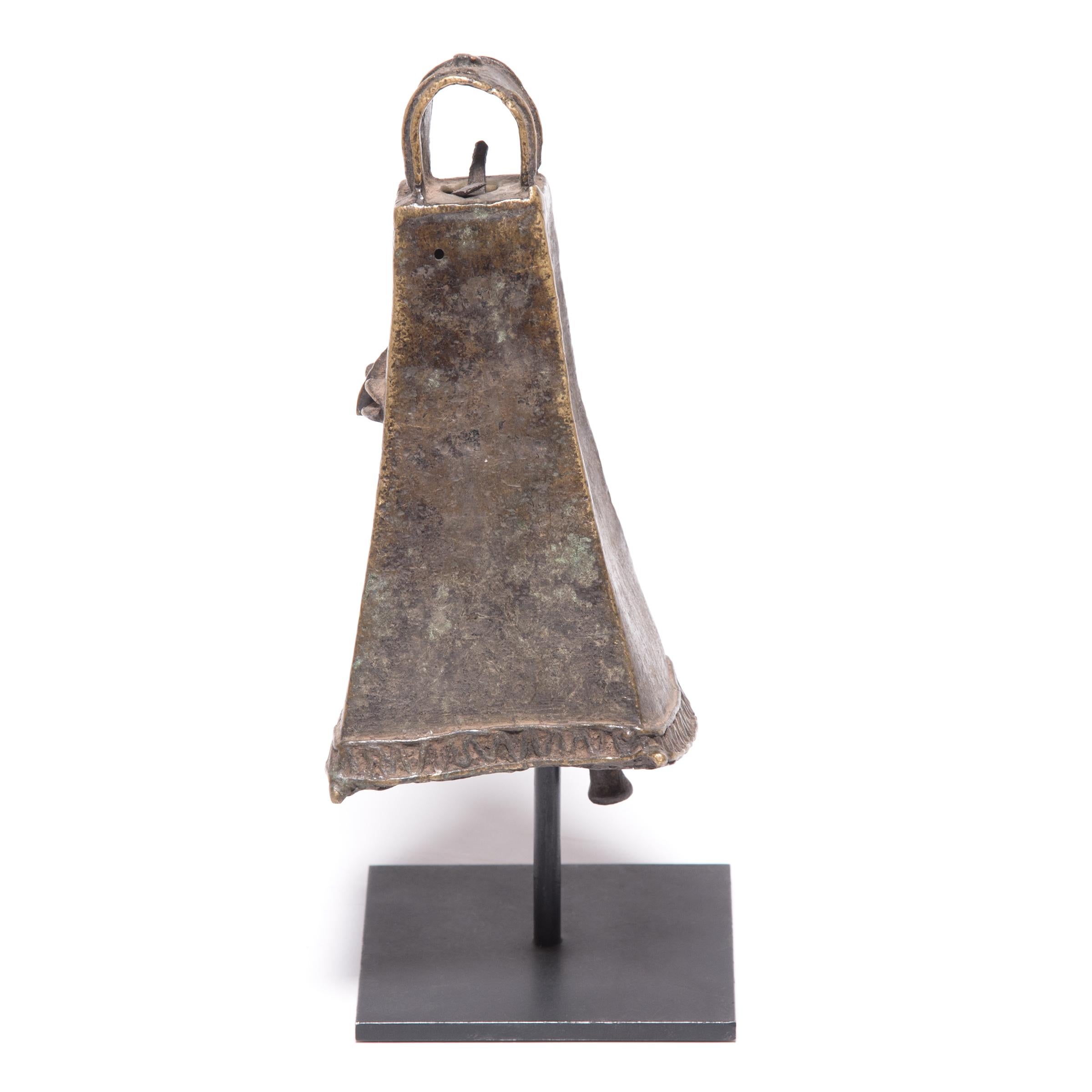 This four-sided brass face bell, known as omo, was created by an artisan of the Ijebu Yoruba people of Southern Nigeria. A mark of the wearer's rank and power, the bell would have been displayed by a prominent chief, worn at the left hip by a long