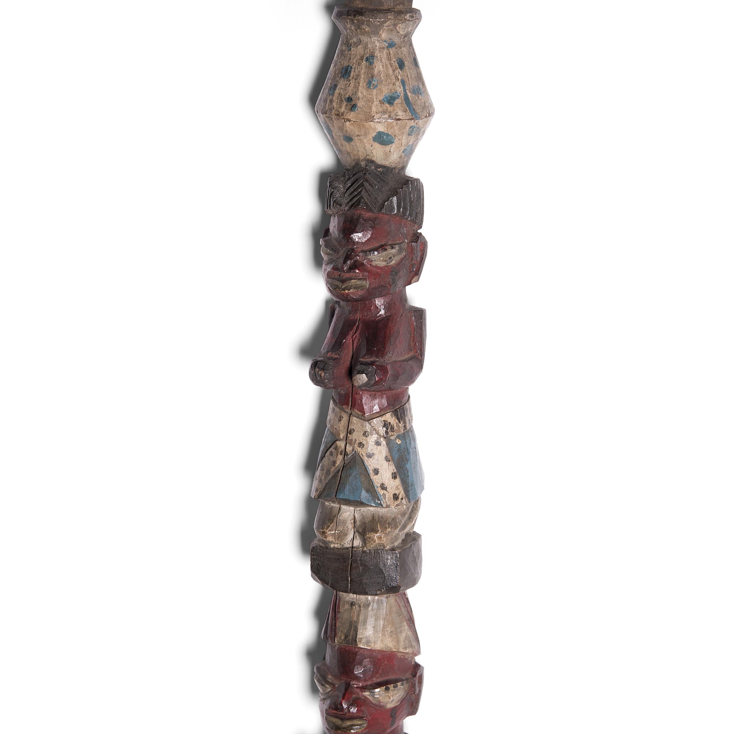 Hand carved with a figurative design, this TOTEM-like wooden post was crafted by an artisan of the Yoruba peoples of Nigeria. Resembling the tall houseposts used to support the roof of a home, this shorter post would have been placed on a veranda