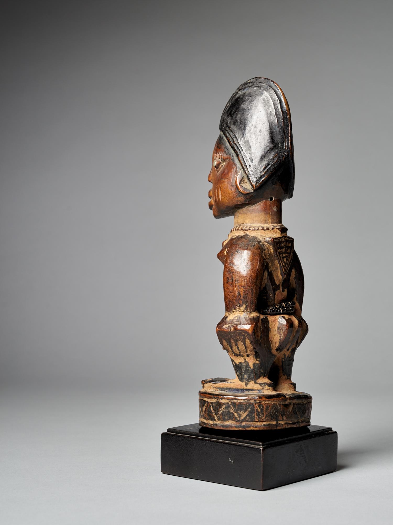 A finely carved big Yoruba Male Ibeji figure with tall headdress, expressive eyes, original bead belt and heavy wear and polish from native use. Areas of encrusted cam wood powder between arms and around feet. Though the cause of the high rate of
